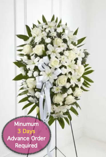 White funeral spray on a stand with ribbon