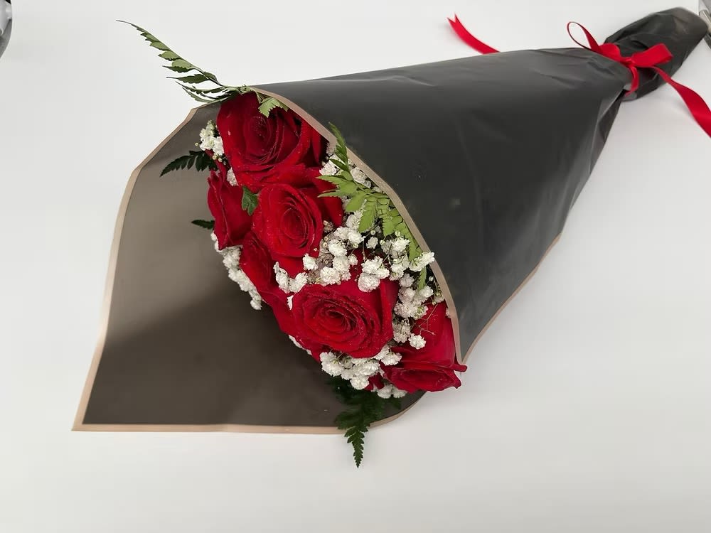 Bouquet of red roses with baby's breath wrapped in black paper
