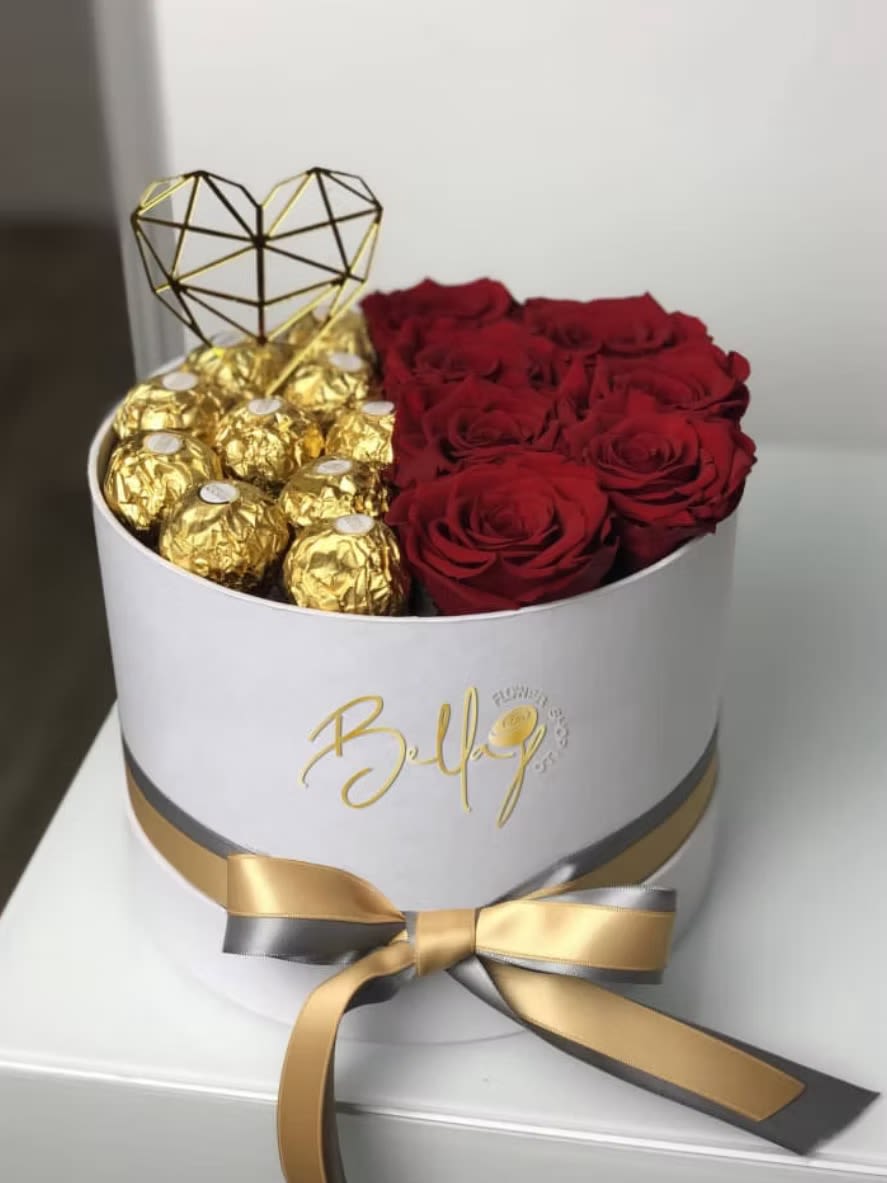 Red roses and gold-wrapped chocolates in a white hat box with a heart topper