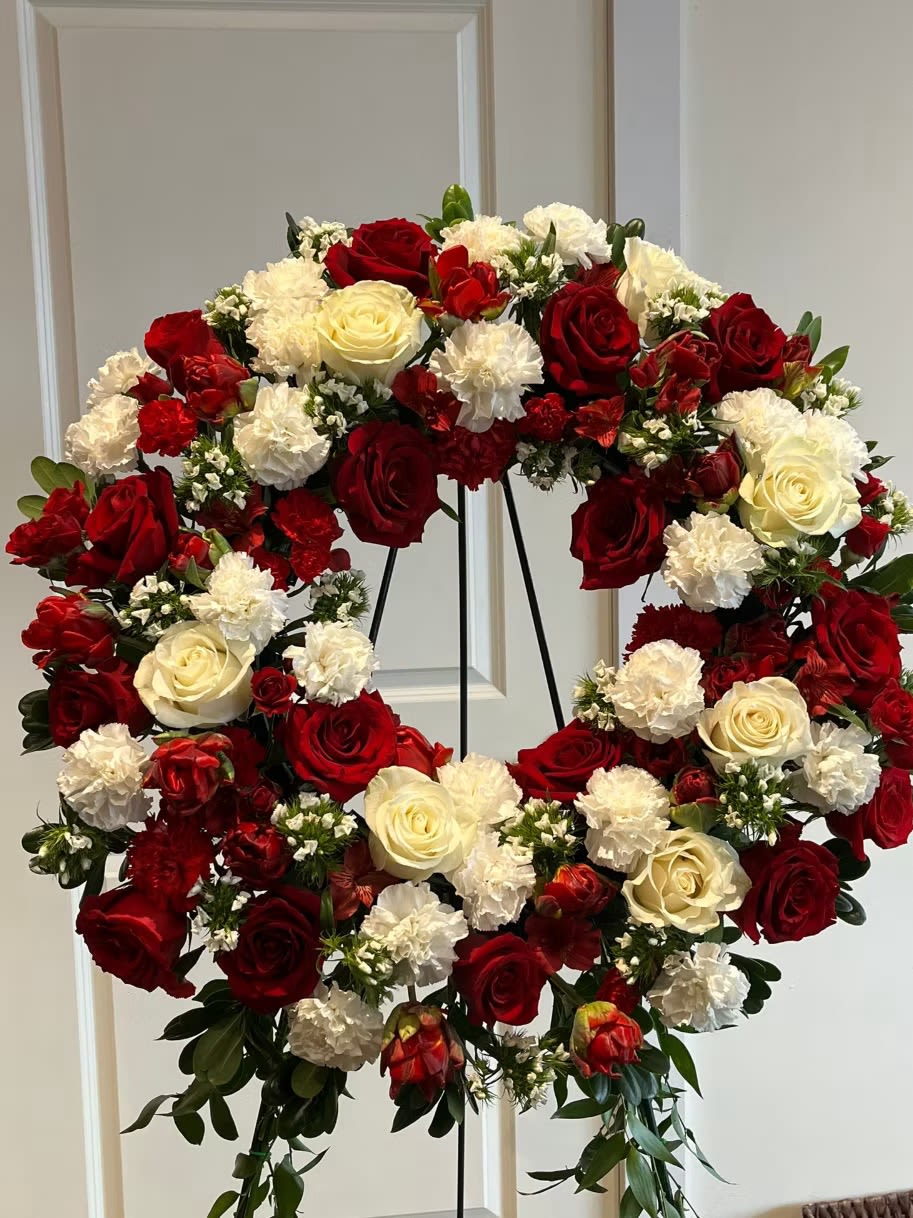 Heart-shaped floral wreath of red and white roses with carnations