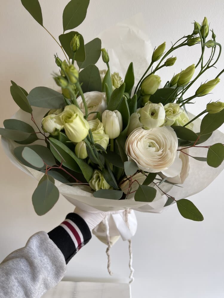 Hand-tied bouquet of white flowers with green buds and eucalyptus