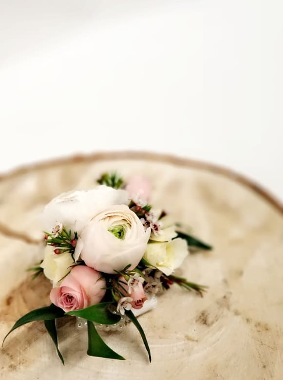 Small bouquet of white and pink flowers on a cream chair