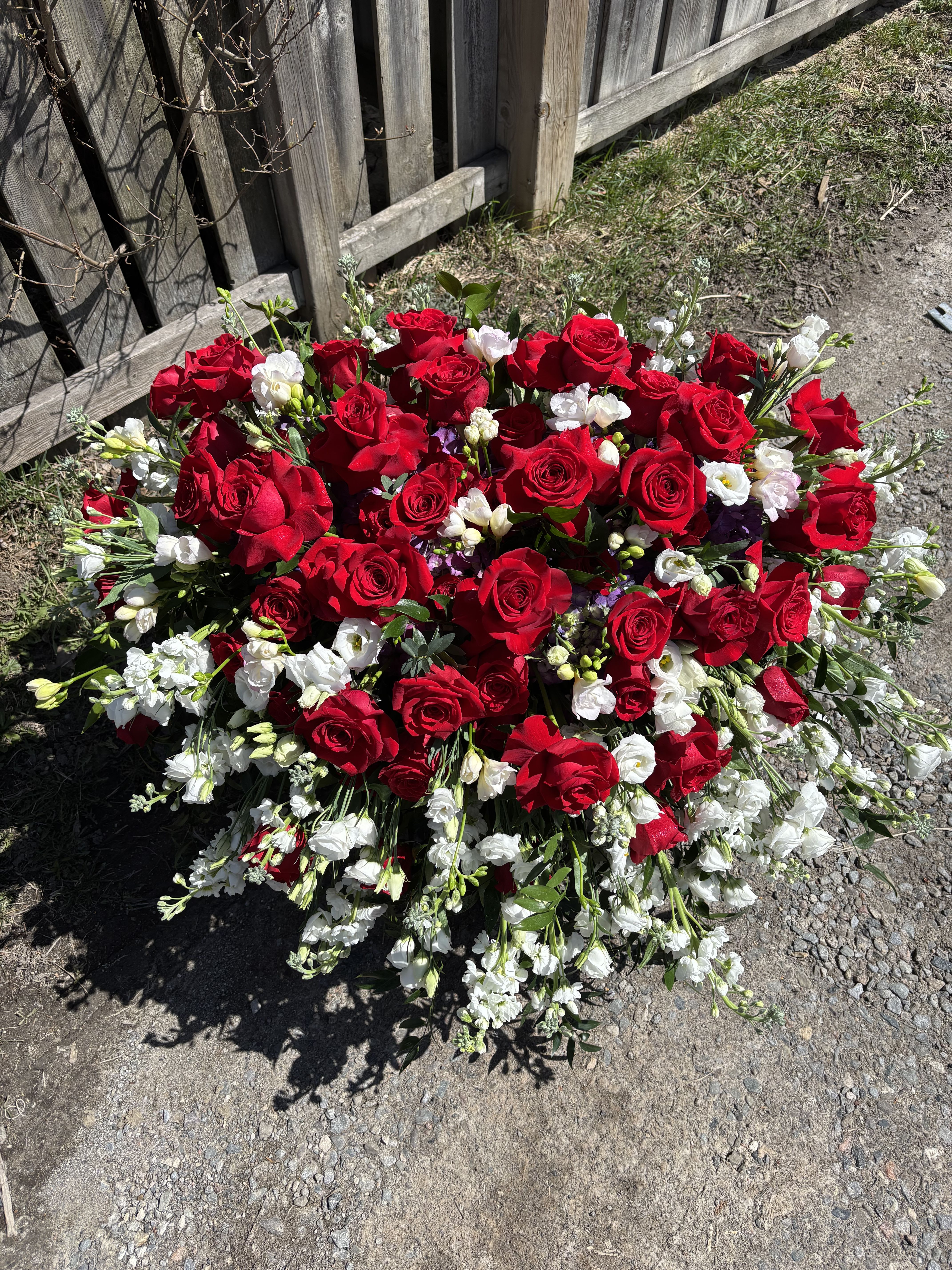 Large bouquet of red roses and white flowers on the ground