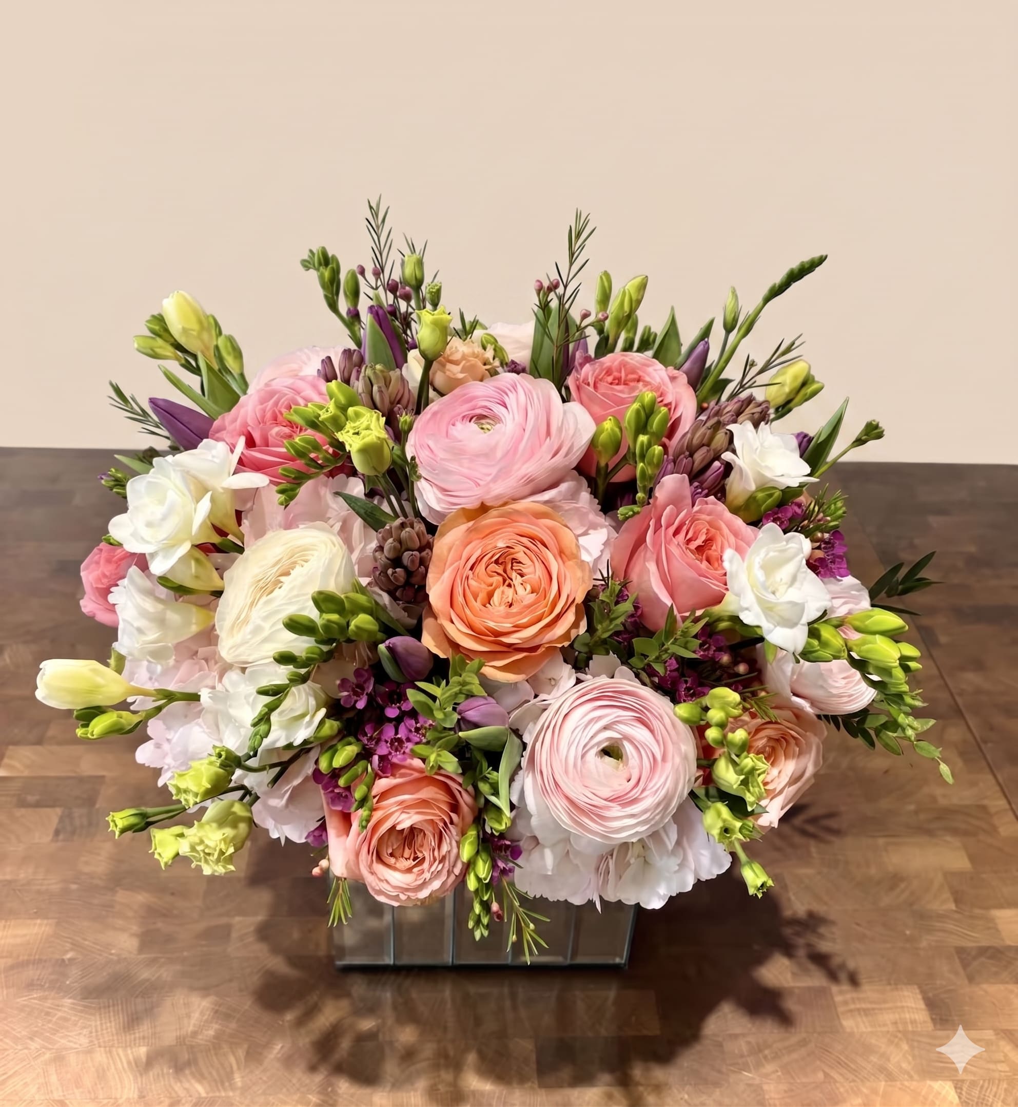 BP13 - Coral Glow  - Coral Glow is a radiant spring arrangement of peach, pink, and purple blooms, exuding warmth and effortless elegance.