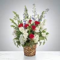 Red and white roses in a woven basket with tall lavender accents