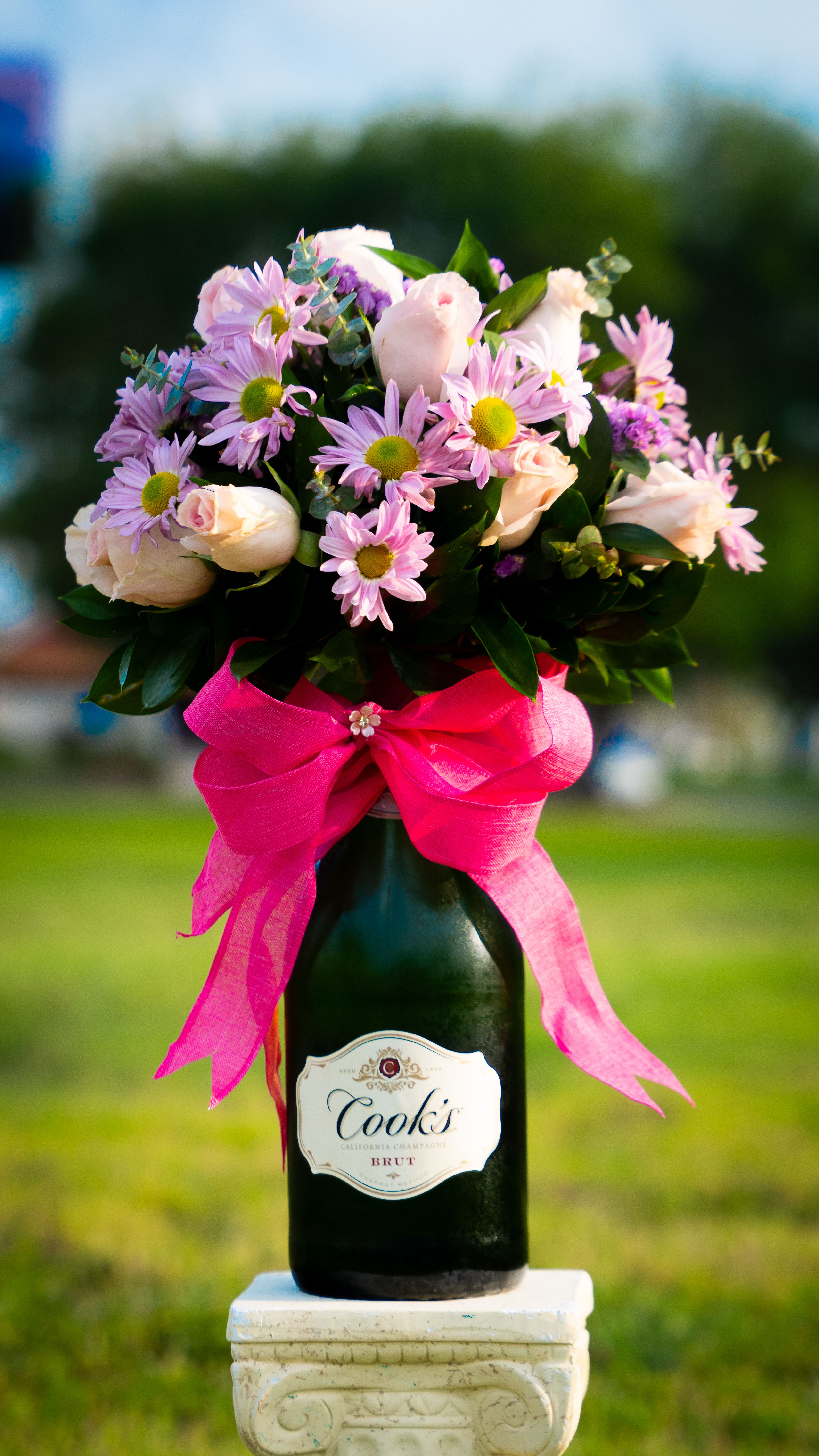 Bottled Blossoms - A perfect pair-- a beautiful bouquet wrapped around a bottle of fine wine. Bottled Blossoms is the ultimate gift to sip, savor, and celebrate.  Customize it with your bottle of choice. Price may vary. 