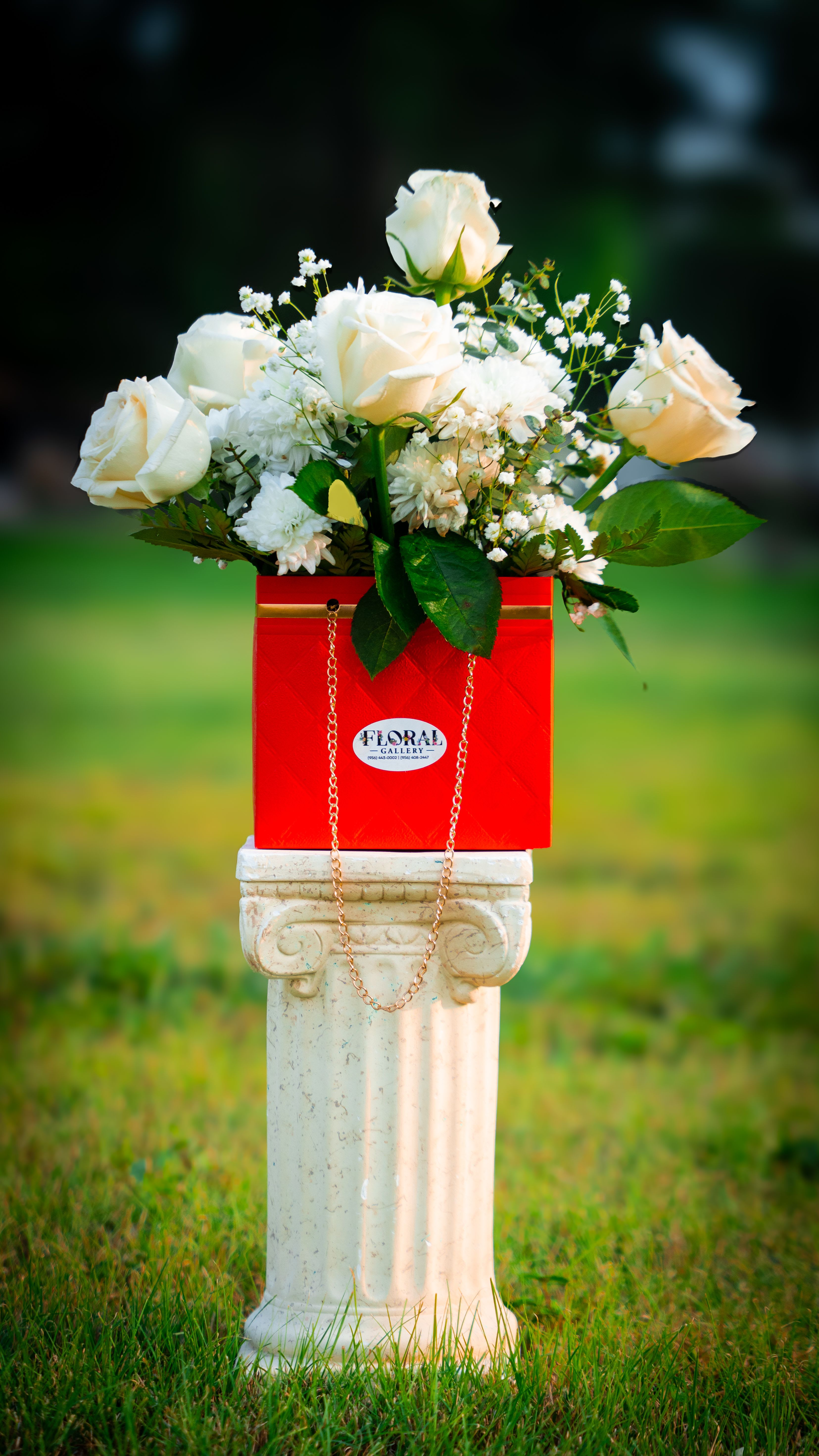 Whispers of Passion - A luxurious blend of white roses and pure white daisies, &amp; baby breathe artfully arranged in a red handbag box with gold accents and a delicate butterfly touch. This elegant design speaks of passion and grace, perfect for expressing love, admiration, or heartfelt appreciation with timeless charm.