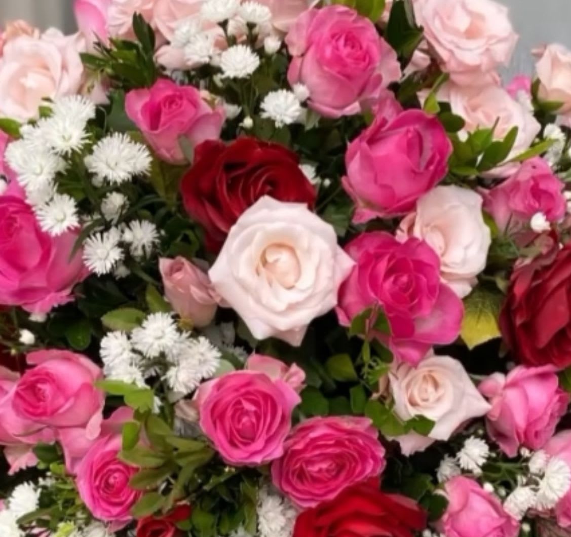 Bouquet of pink, red, and white roses with small white filler flowers