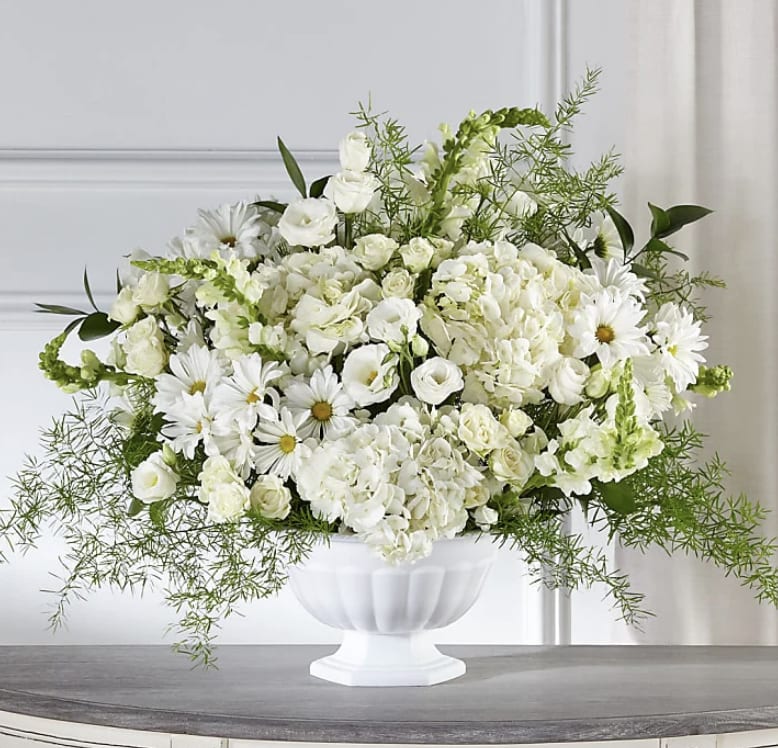 White floral arrangement in a white pedestal vase