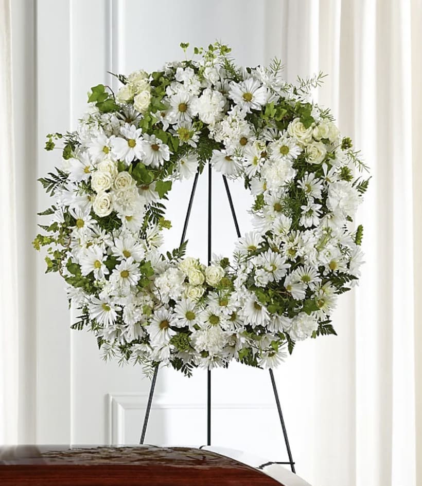 White floral wreath on a black easel
