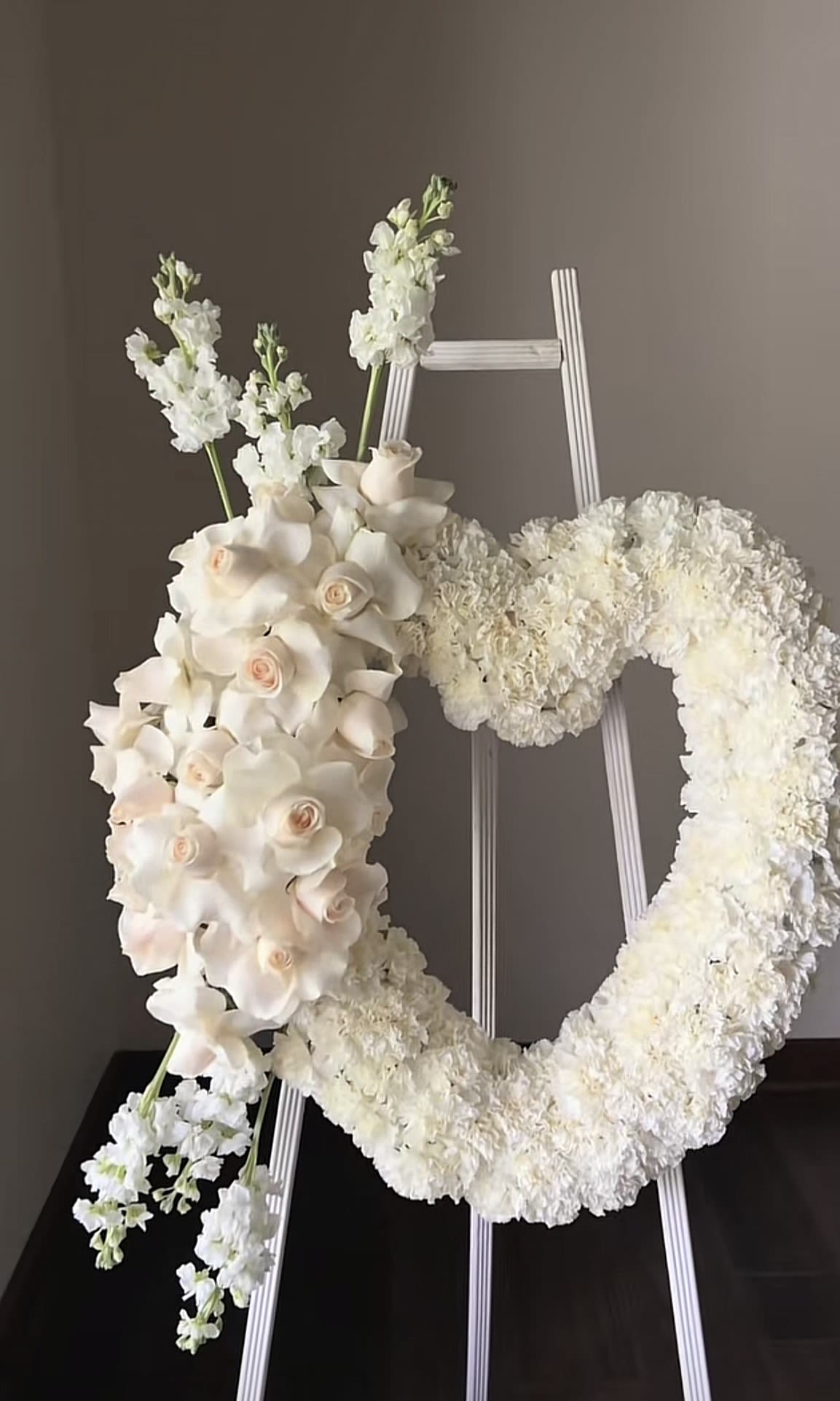 White floral wreath and cascading bouquet on a stand