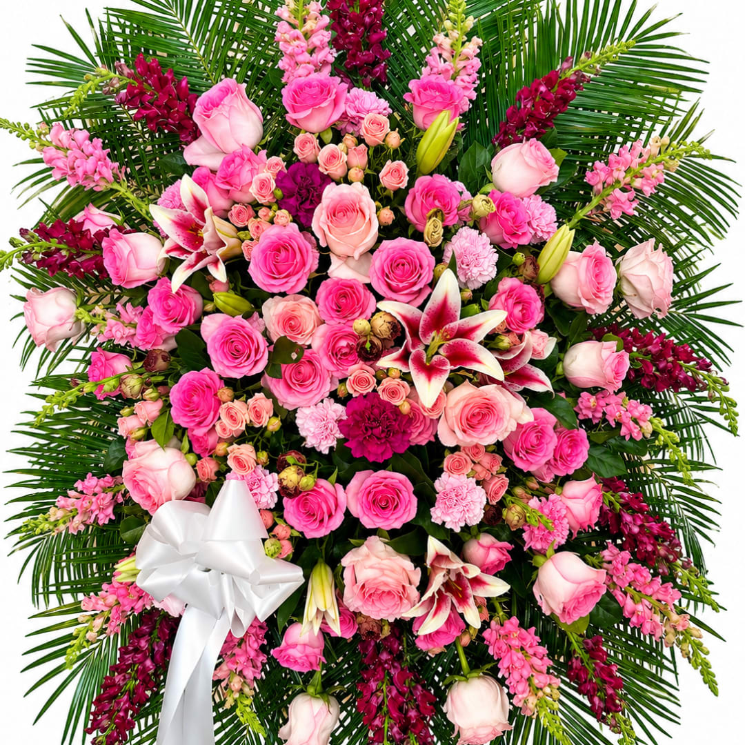 Large pink and white floral spray with a white ribbon bow