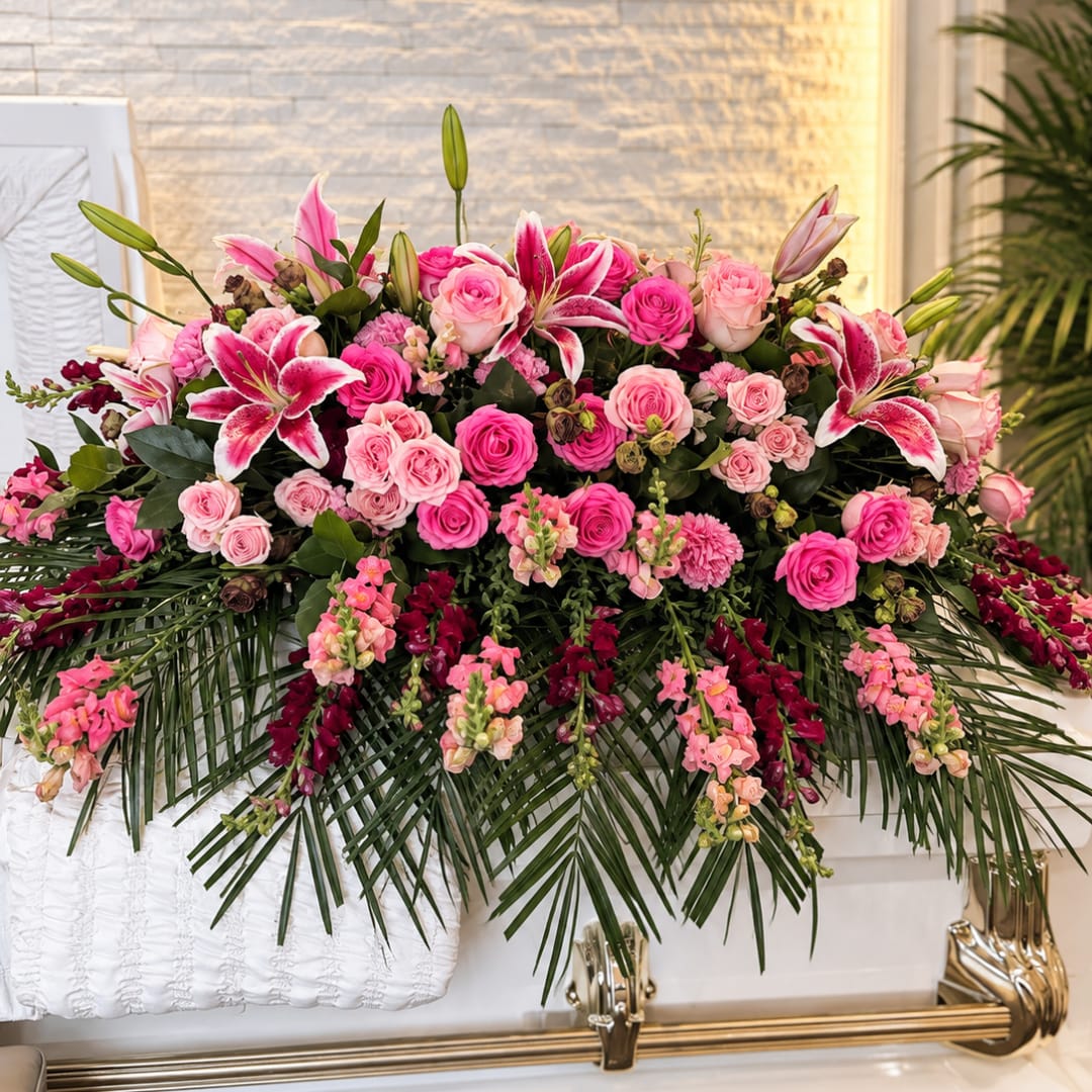Large pink floral casket spray with roses and lilies