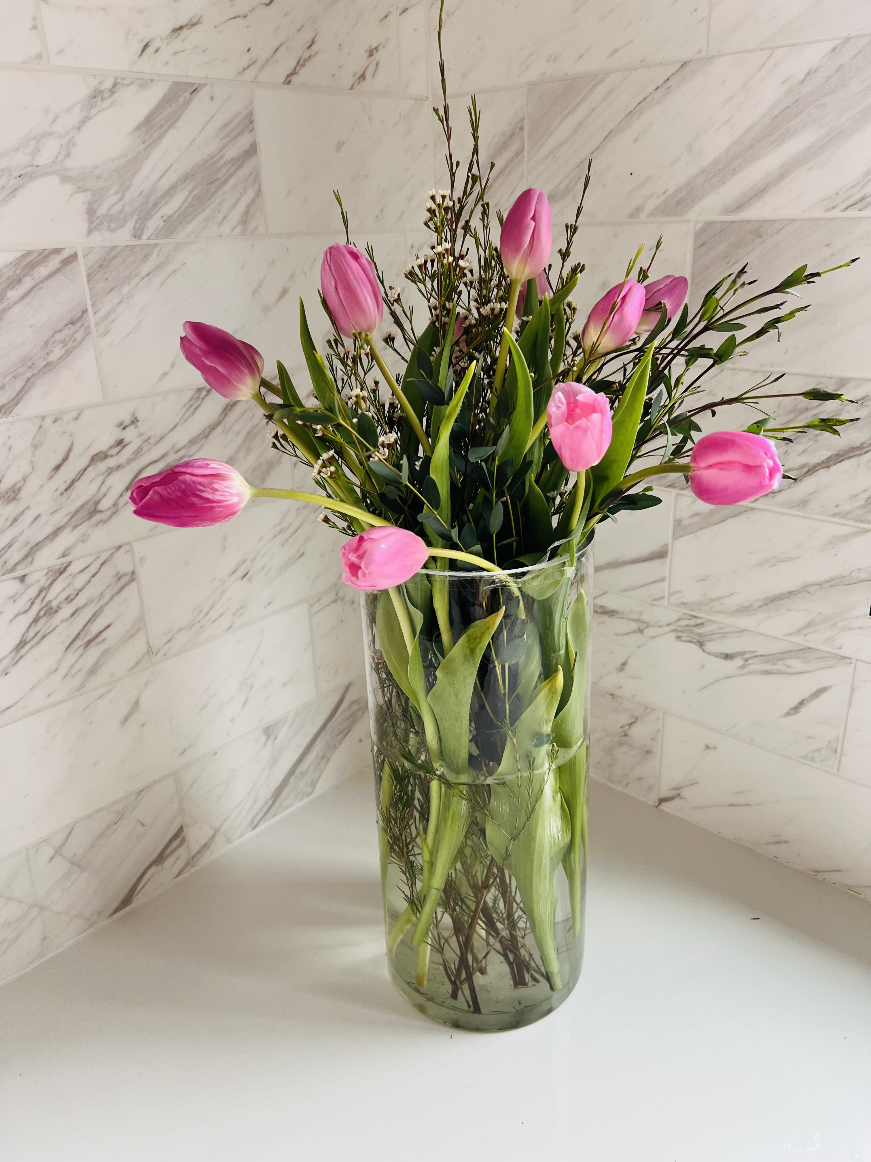 Pink tulips arranged in a clear glass vase