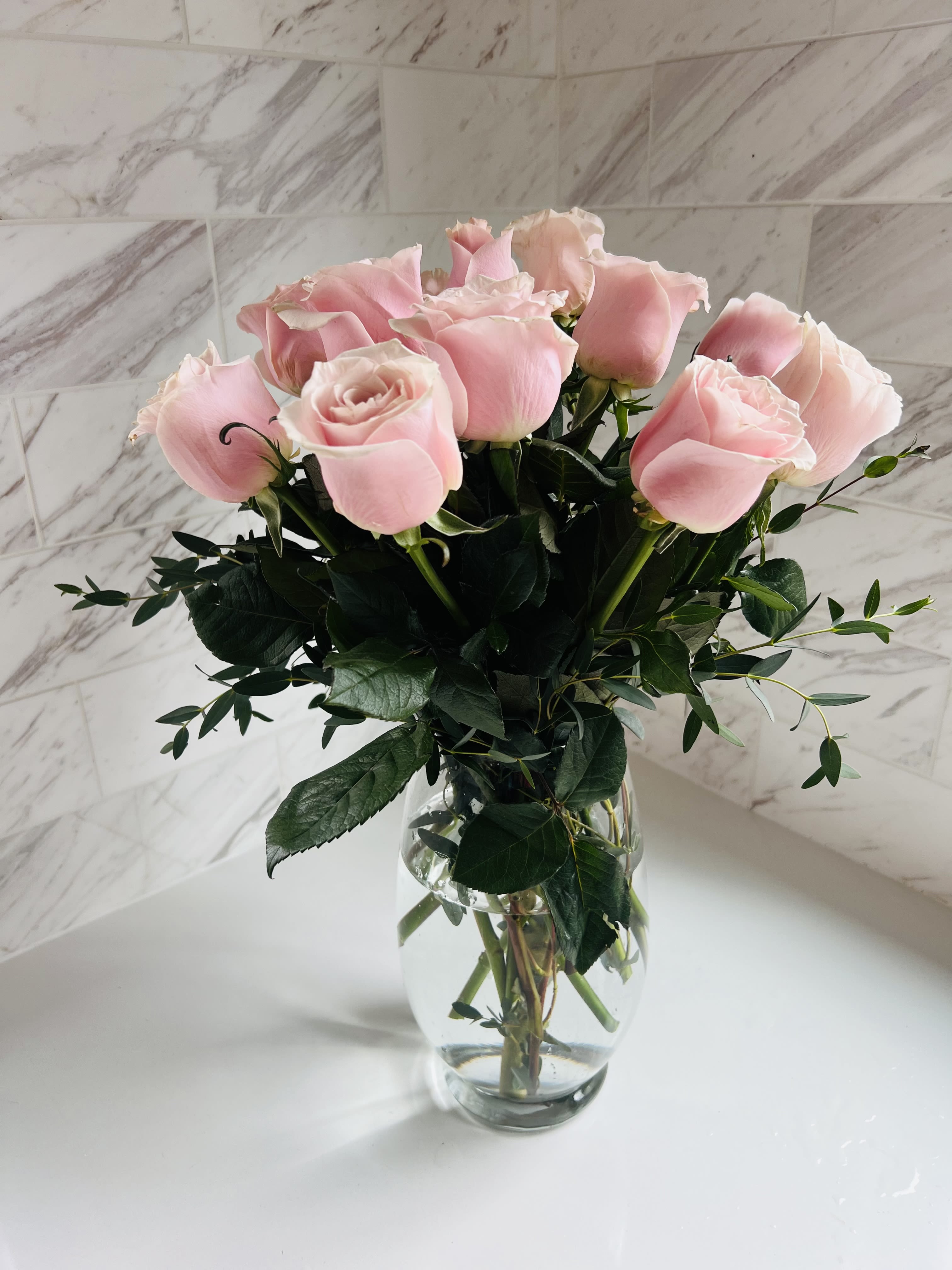 Pink roses arranged in a clear glass vase