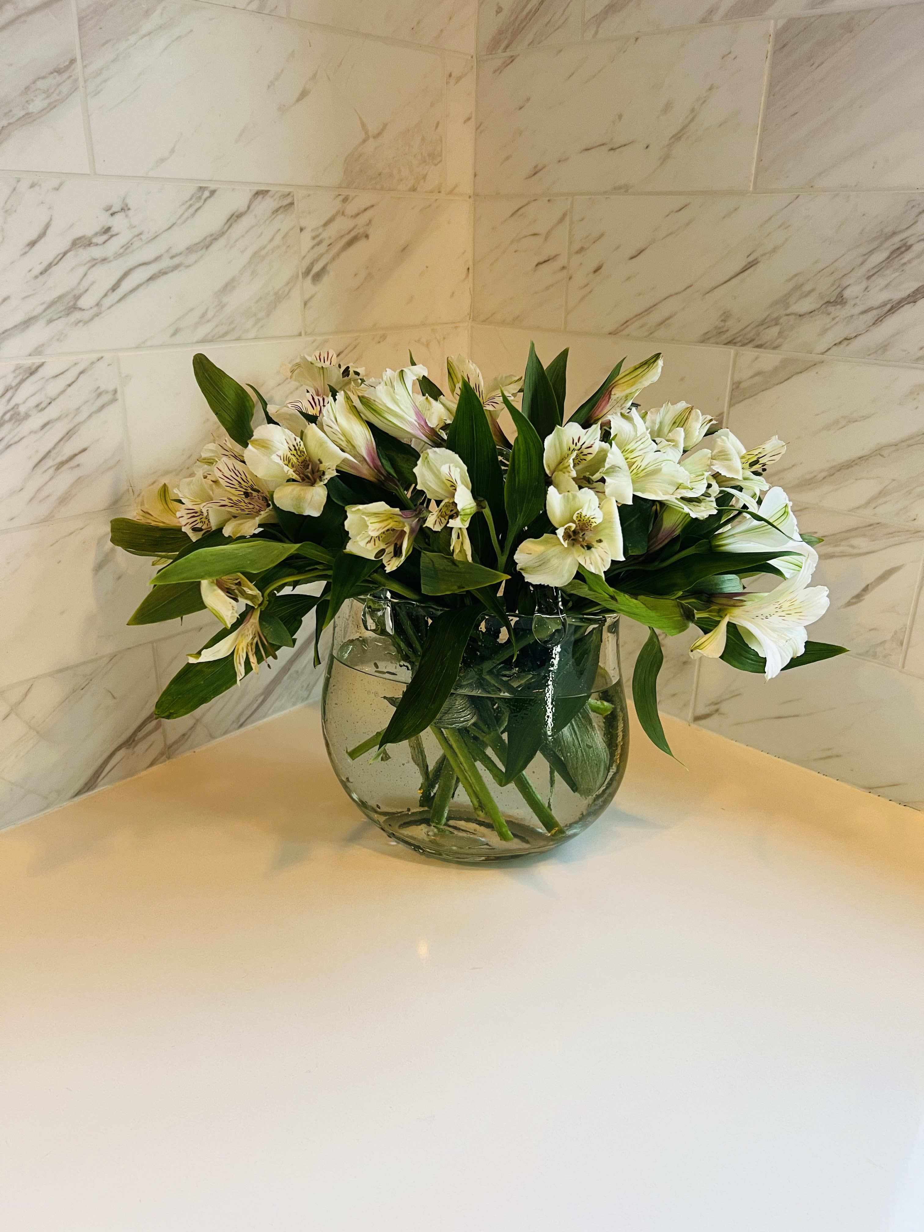 White alstroemeria bouquet in a clear glass vase