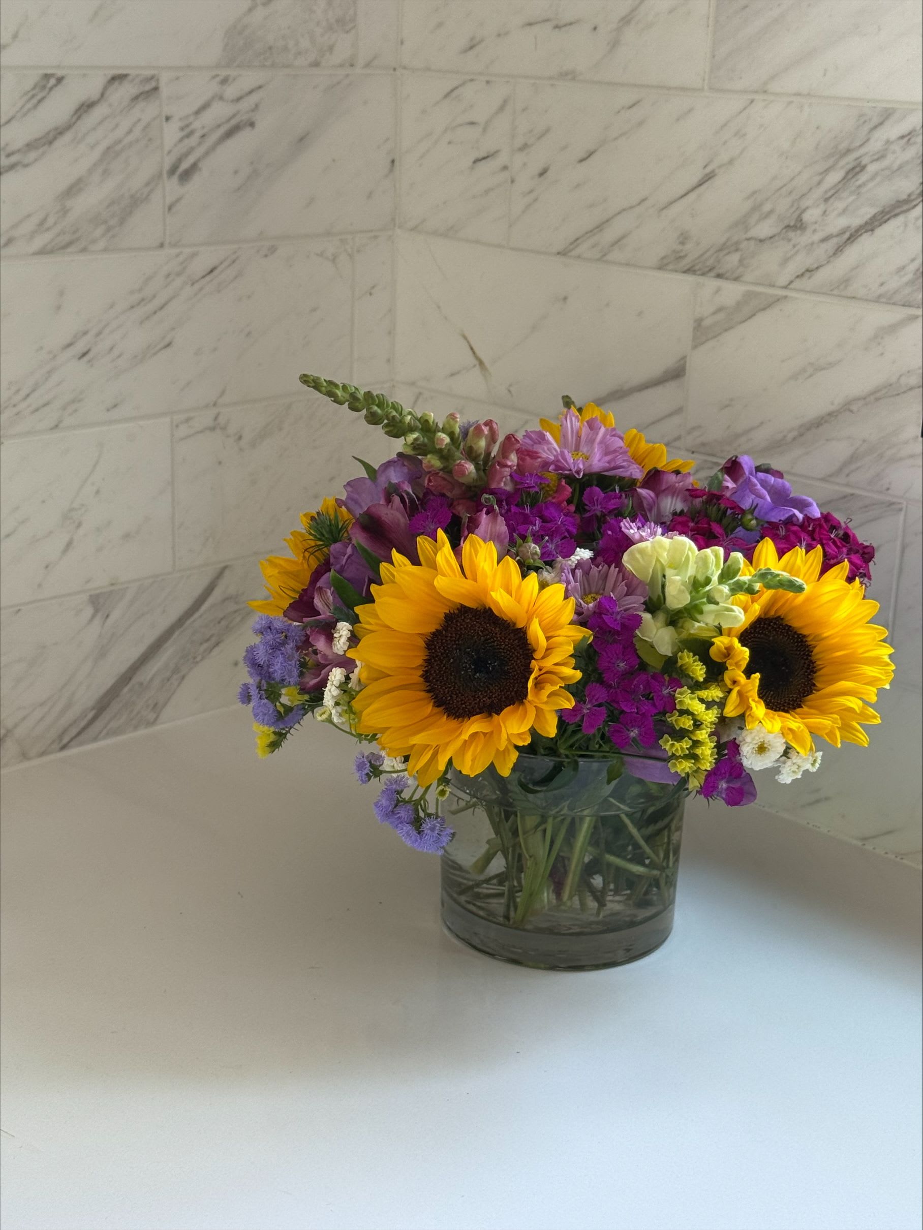 Mixed bouquet with sunflowers in a glass vase