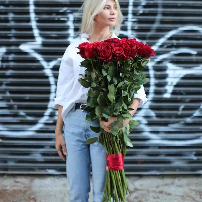 Woman holding a large bouquet of red roses
