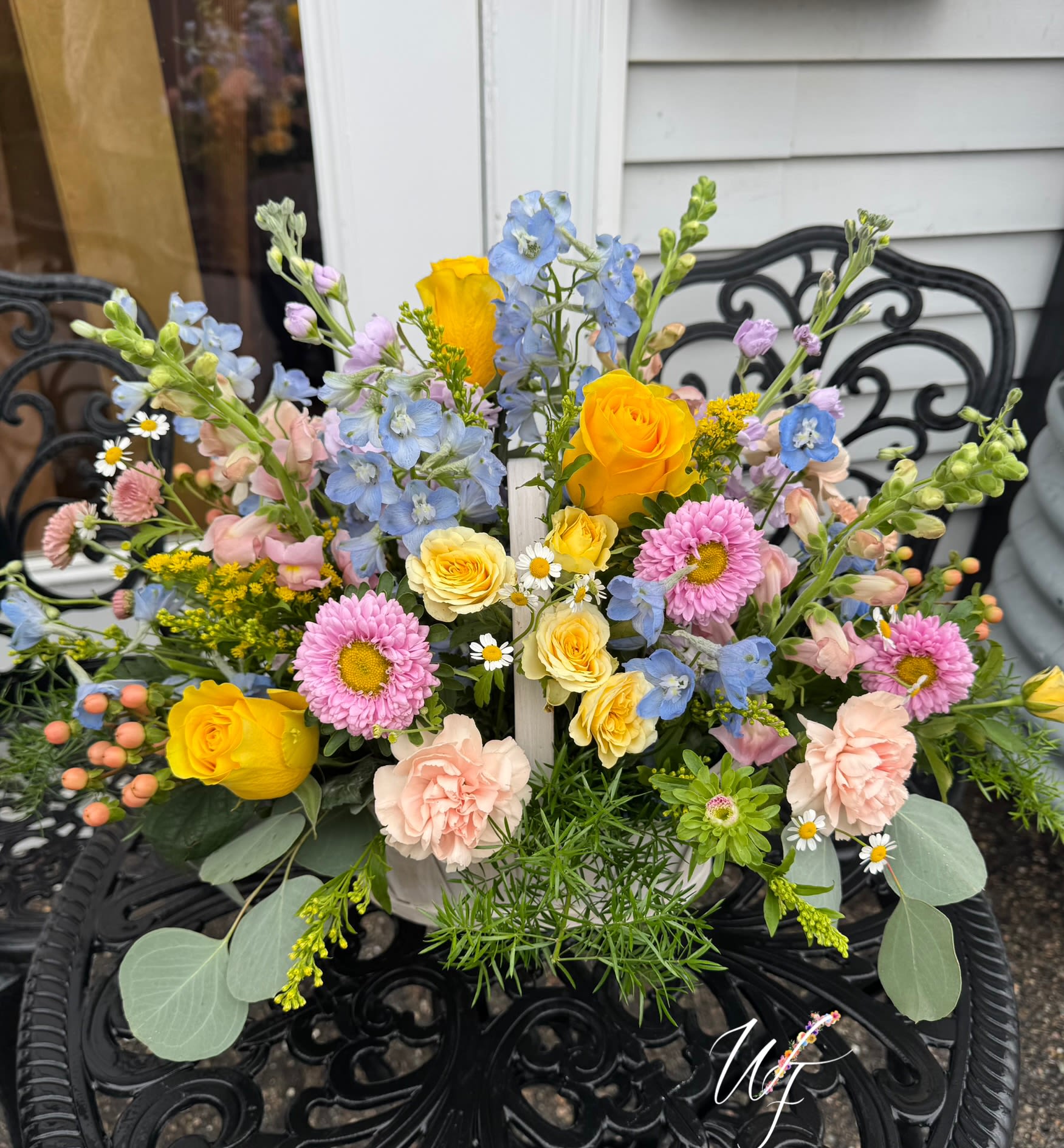 Mixed bouquet with yellow roses, pink daisies, and blue flowers