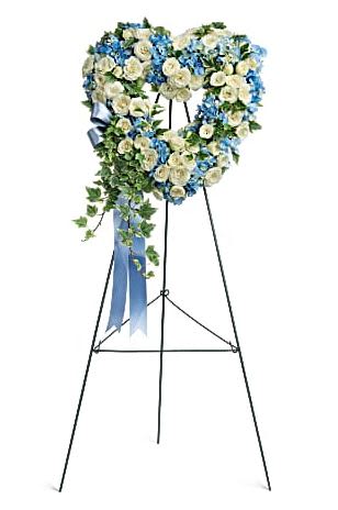 Heart-shaped floral wreath on a standing easel with blue and white flowers