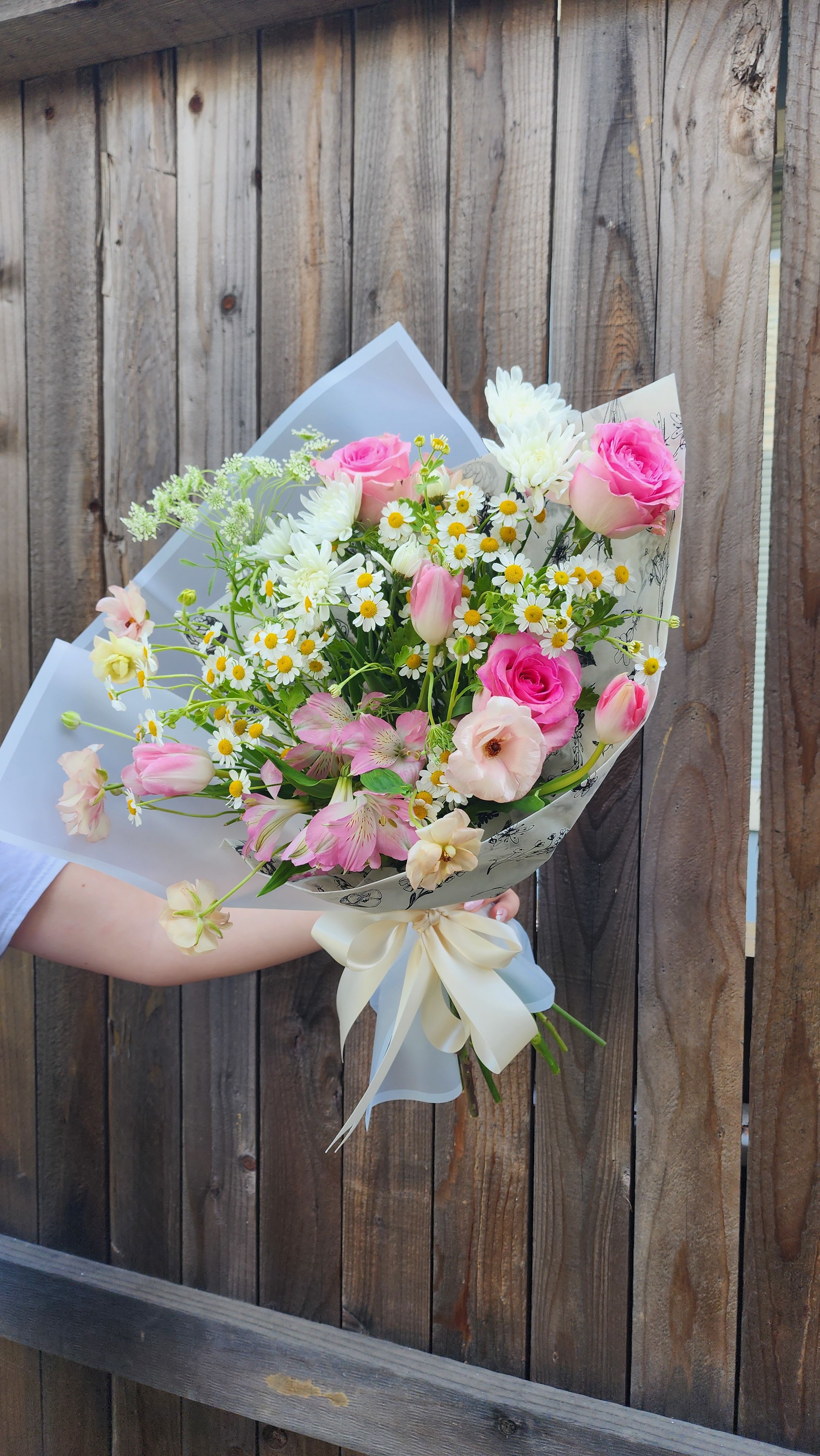 Spring Hand Wrapped Bouquet with wildflowers-Designers Choice  - This is a Hand Wrapped Bouquet in Spring Colors with some roses, tulips and wildflowers. The color scheme of this arrangement can be changed by our designers based on the occasion of the event, Mother's day or any other holiday. 