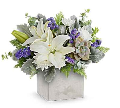 White lilies and purple flowers arranged in a square box