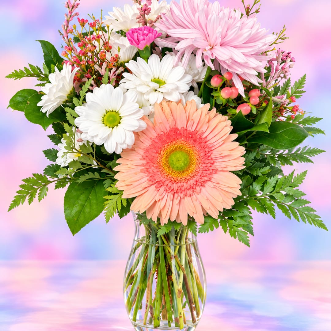 Mixed bouquet of pink and white daisies in a clear glass vase
