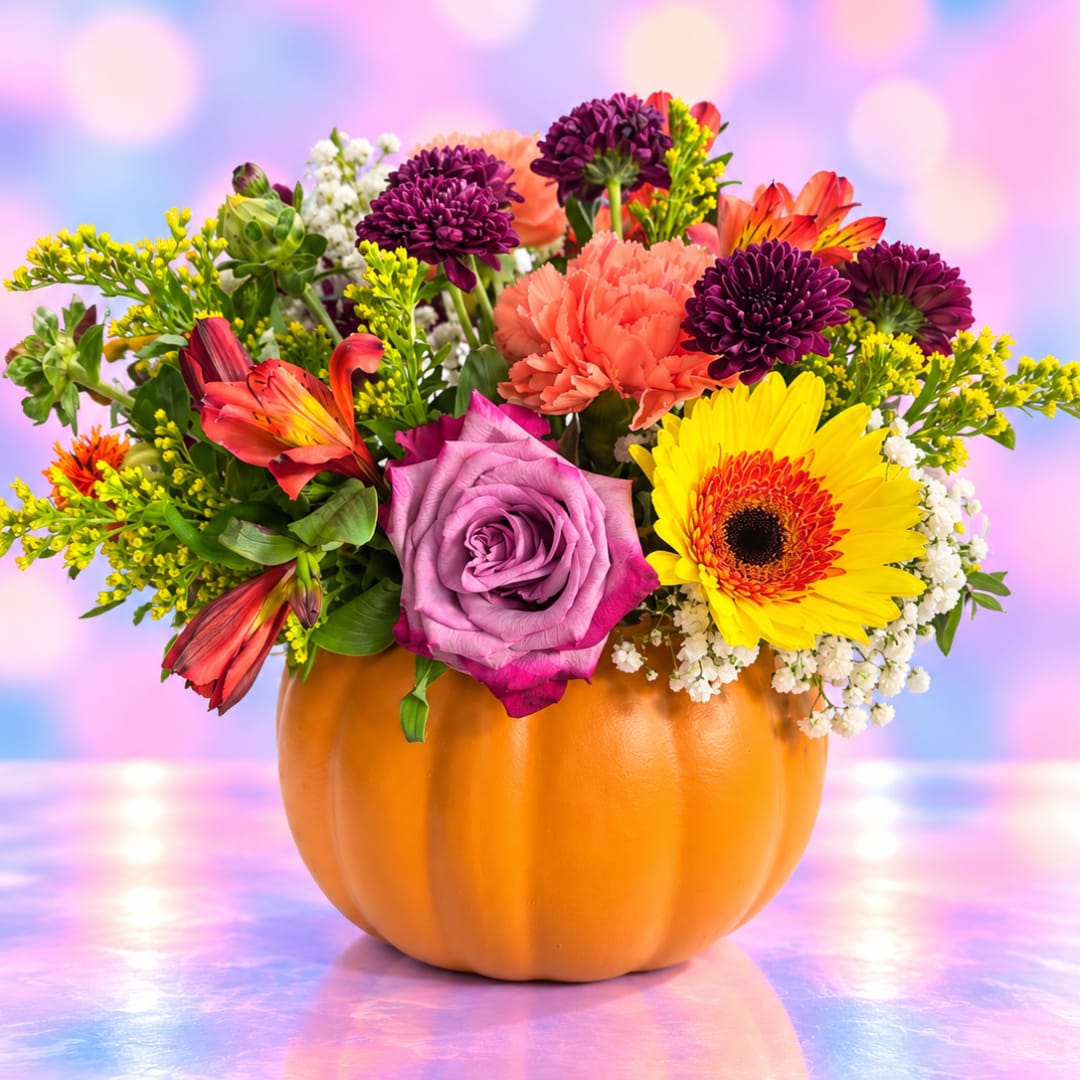 Mixed bouquet in a pumpkin-shaped orange container with bright flowers