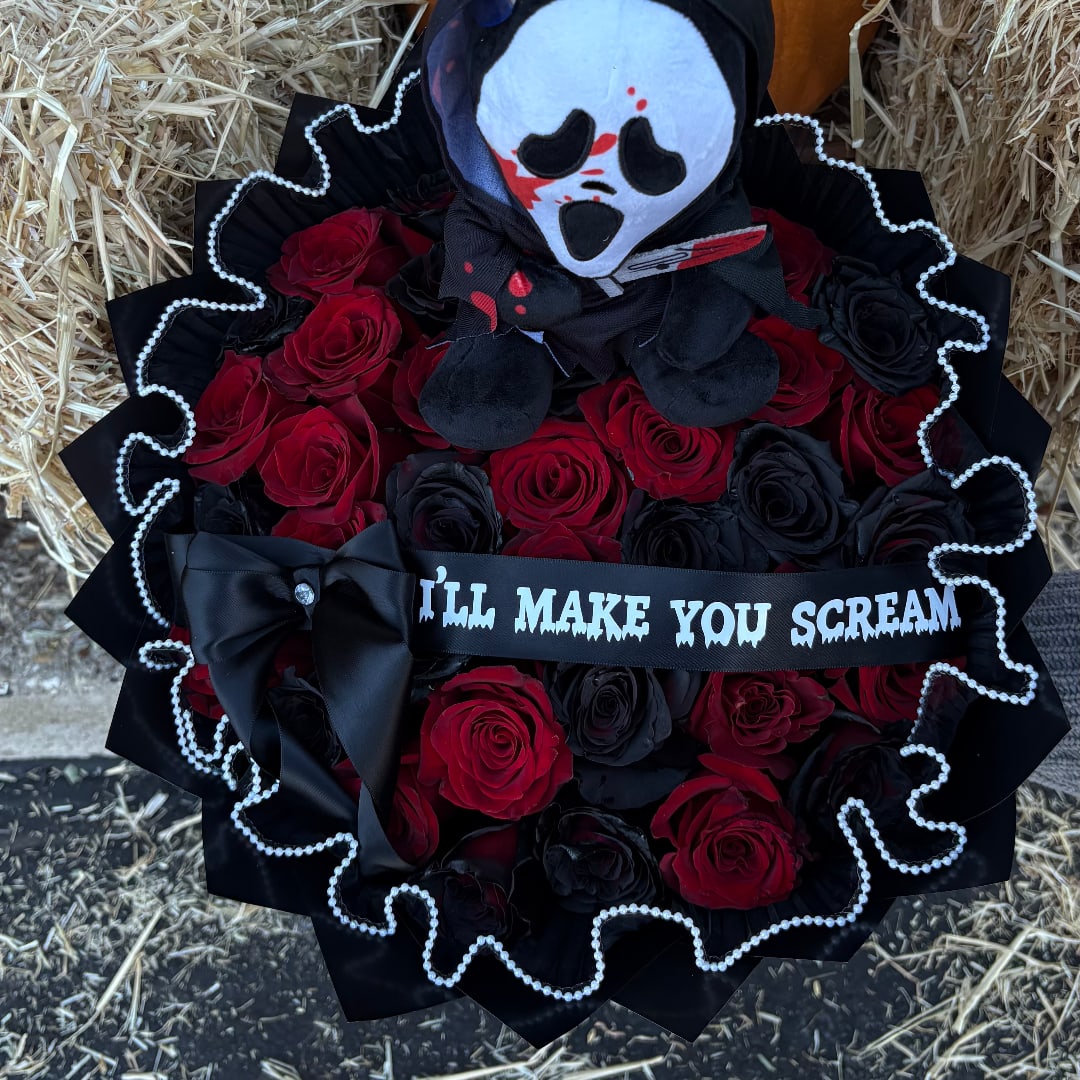 Bouquet of red and black roses with a skull doll and black ribbon
