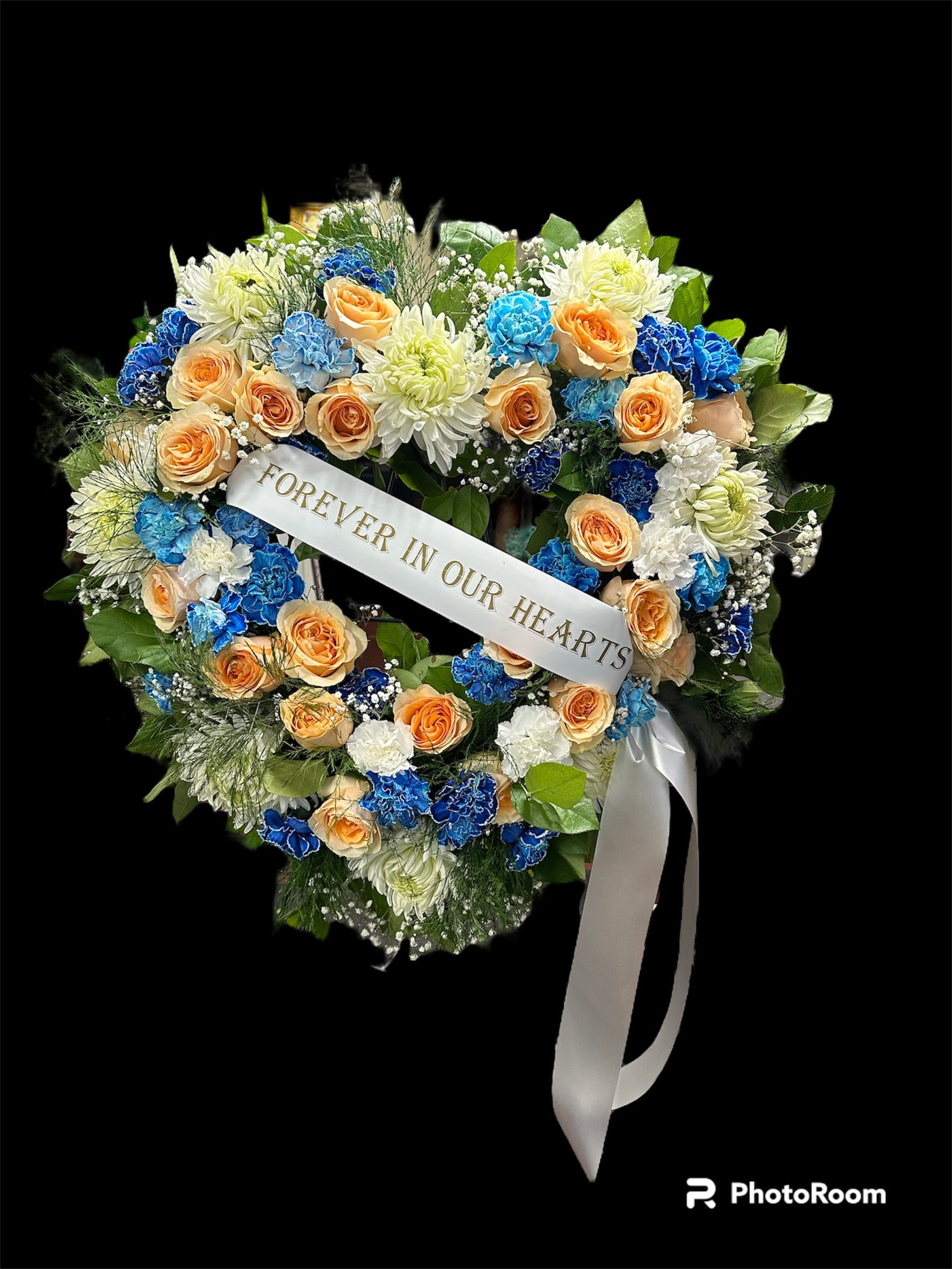 Open Heart with custom ribbon  - A heart shaped floral wreath featuring peach roses, blue and white carnations and lush greenery,accented with a customizable ribbon message- a thoughtful tribute for memorial services. please  