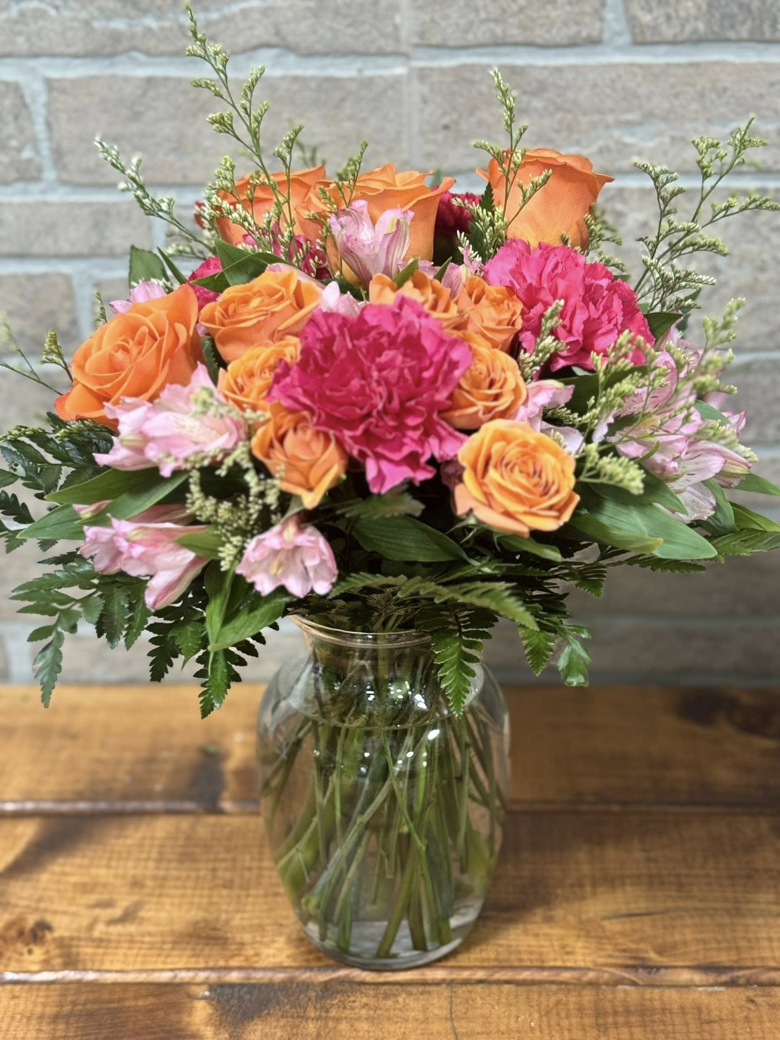 Sunset Crush Bouquet - Bright, bold, and bursting with joy, the Sunset Crush Bouquet is a radiant mix of vibrant orange and hot pink blooms accented with soft touches of golden yellow. Designed to capture the warmth and energy of a glowing sunset, this arrangement brings together eye-catching seasonal flowers in a lively, modern style. Perfect for birthdays, celebrations, get-well wishes, or simply sending a burst of happiness, this bouquet delivers color, charm, and unforgettable beauty in every stem. Handcrafted with care by Blessings In Bloom Florals, it’s a stunning choice when you want to make a statement and brighten someone’s day.