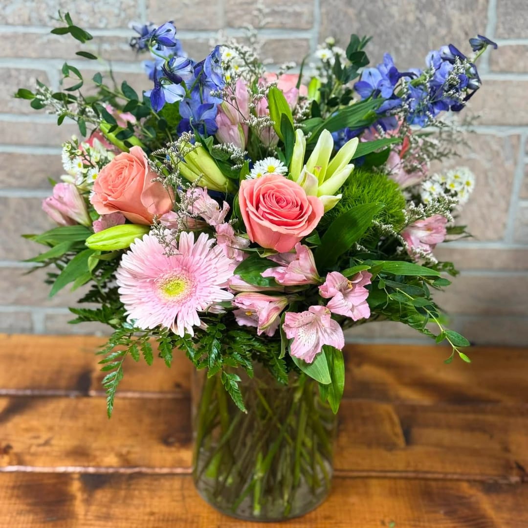 Pink and blue mixed bouquet in a clear glass vase