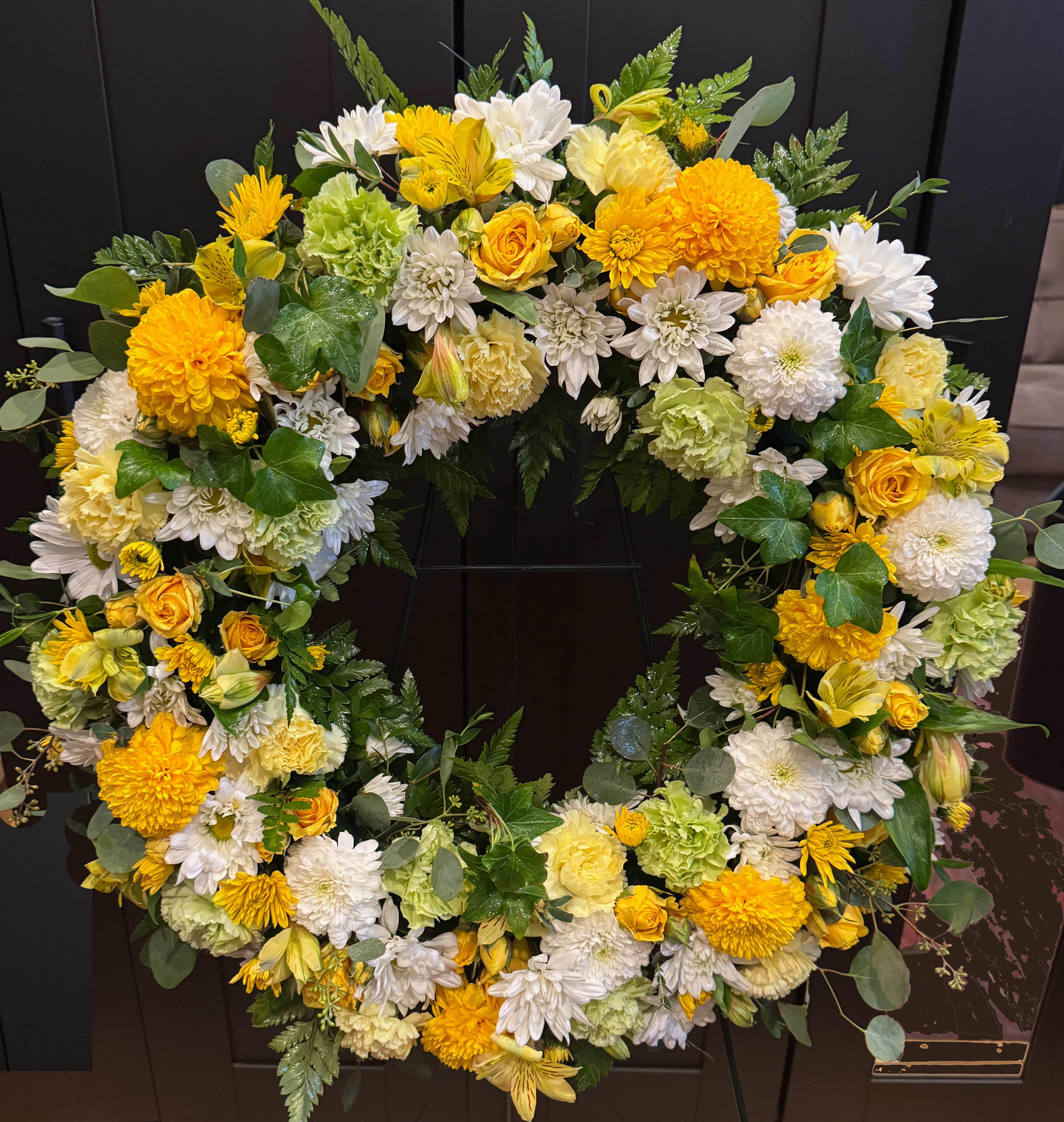 Large yellow and white floral wreath with mixed blooms