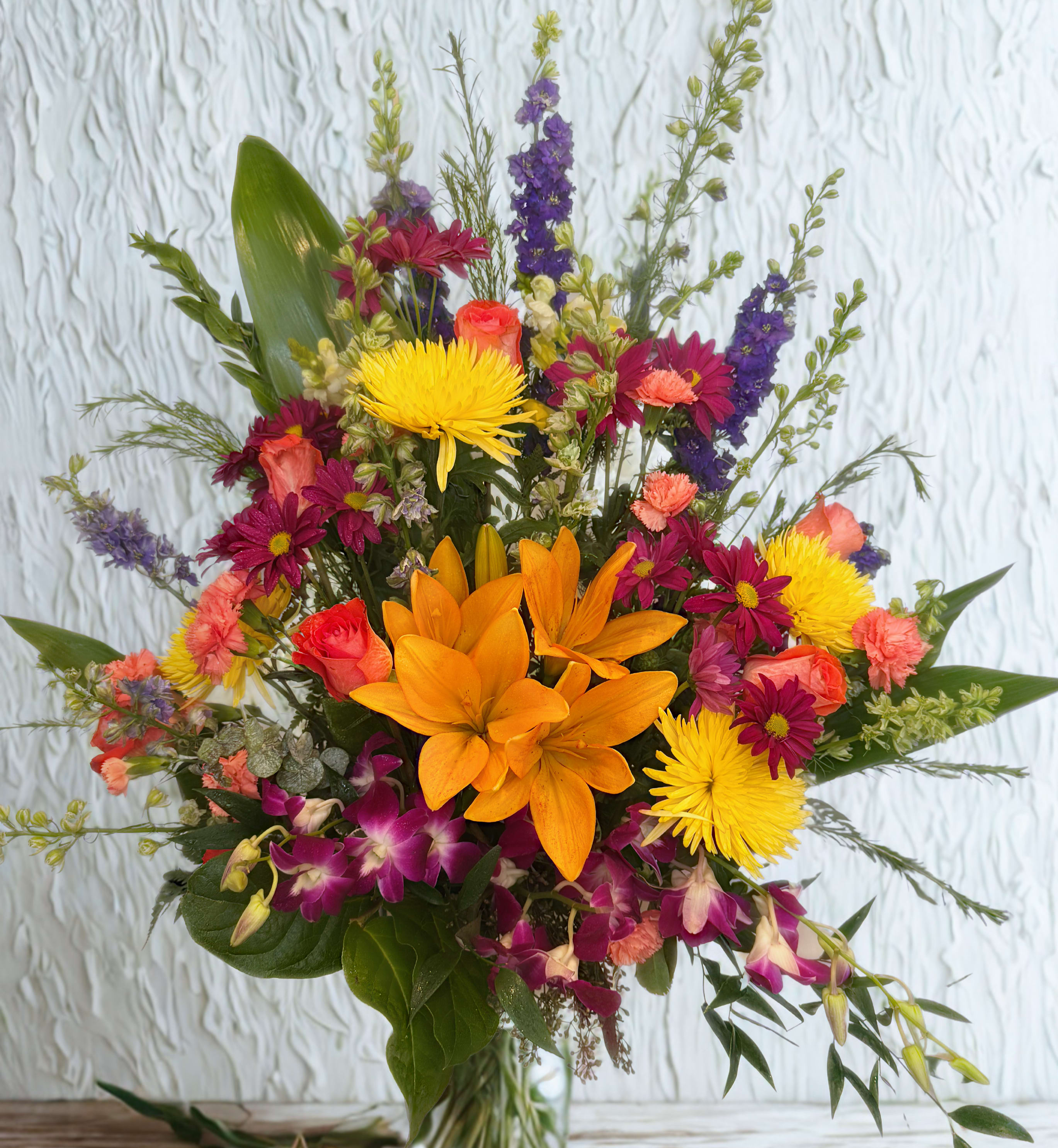 Mixed bouquet with orange lilies, yellow mums, and purple orchids