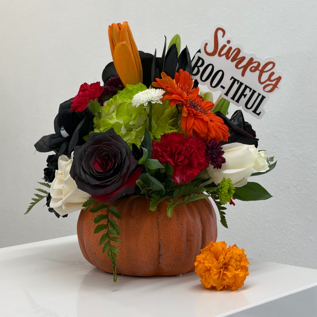 Floral arrangement in a pumpkin container with a "Simply BOO-TIFUL" sign