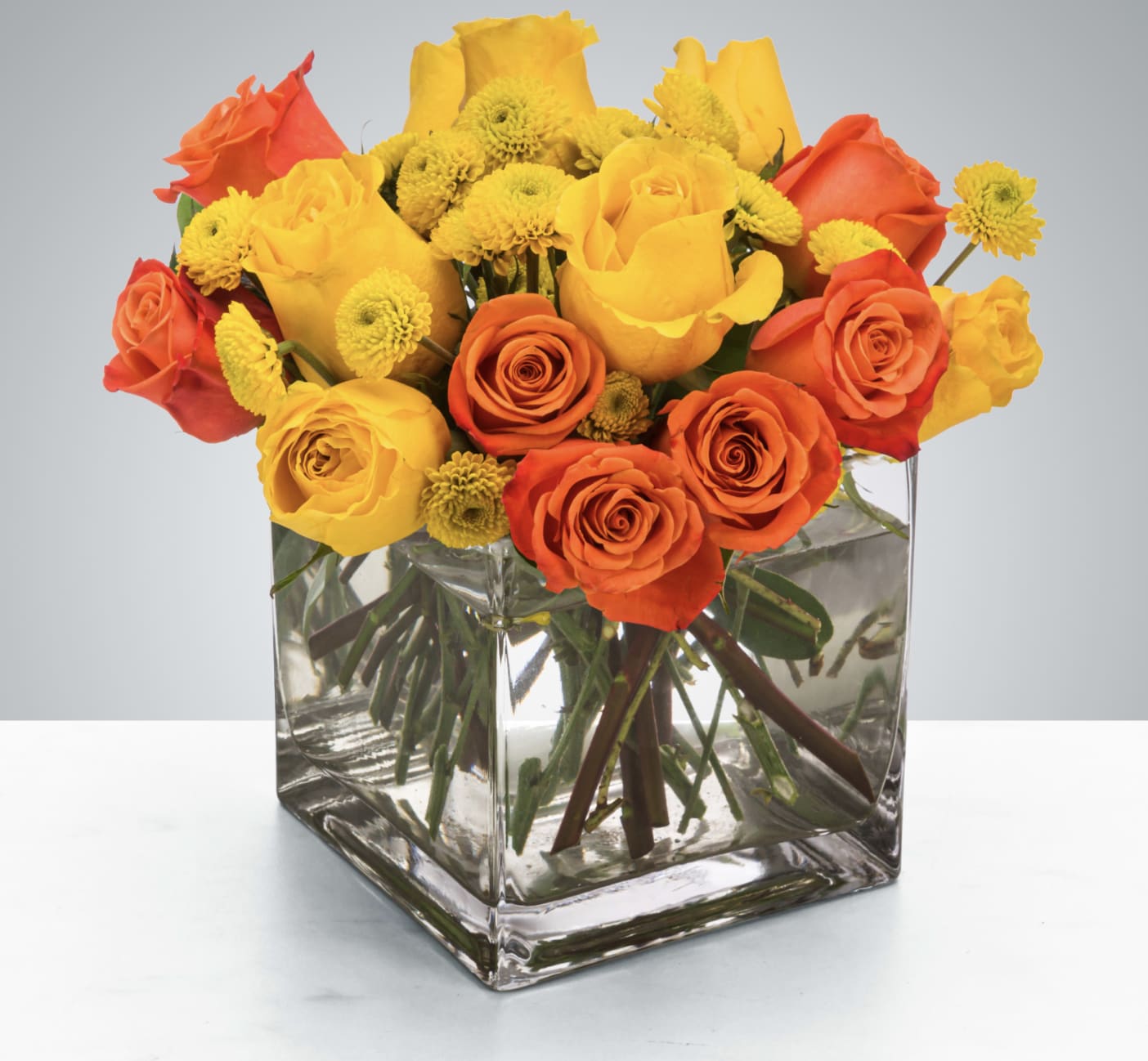 Zara - Yellow and orange roses come together for a fun and fresh arrangement. A great arrangement to send to both men and women as a gift, these flowers light up any room. Send this for admin professionals week, Cinco De Mayo, or a birthday.  Approximate Dimensions: 10"D x 10"H