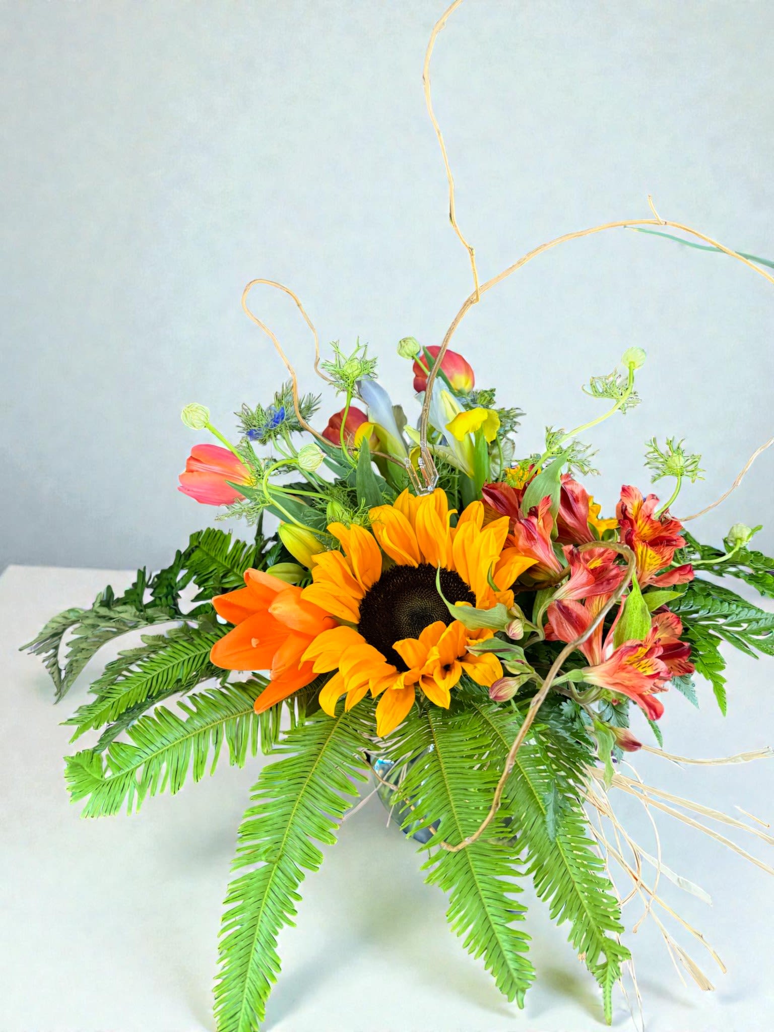 Bright mixed bouquet with sunflowers and orange blooms