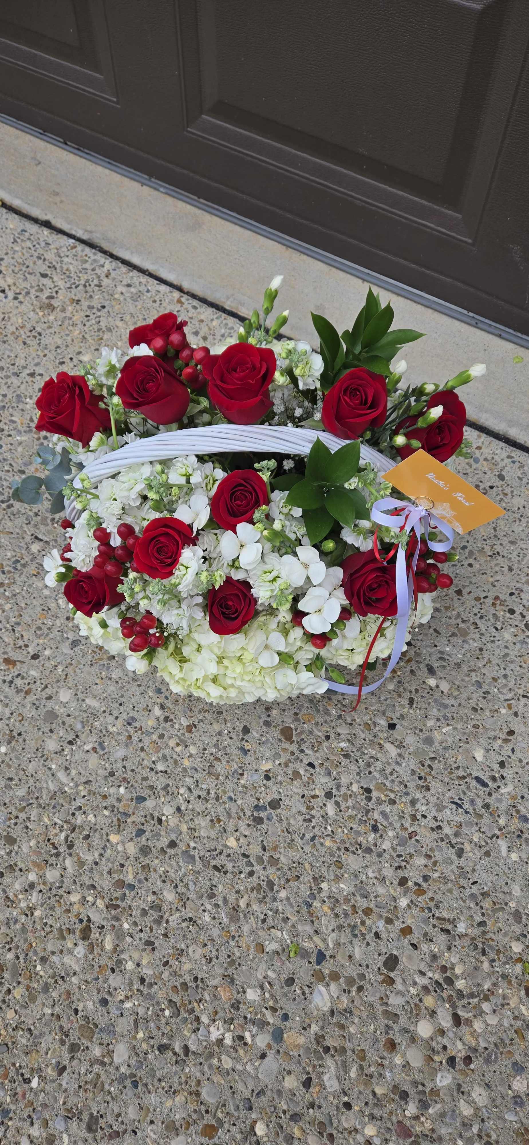 Basket arrangement of red roses and white flowers with ribbon