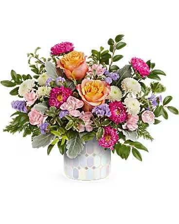 Mixed bouquet of pink, orange, and white flowers in a patterned vase