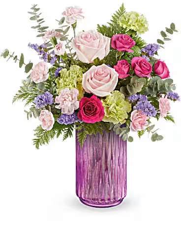 Pink and purple rose bouquet in a tall purple glass vase