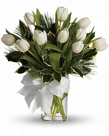 White tulips arranged in a clear glass vase with a white ribbon