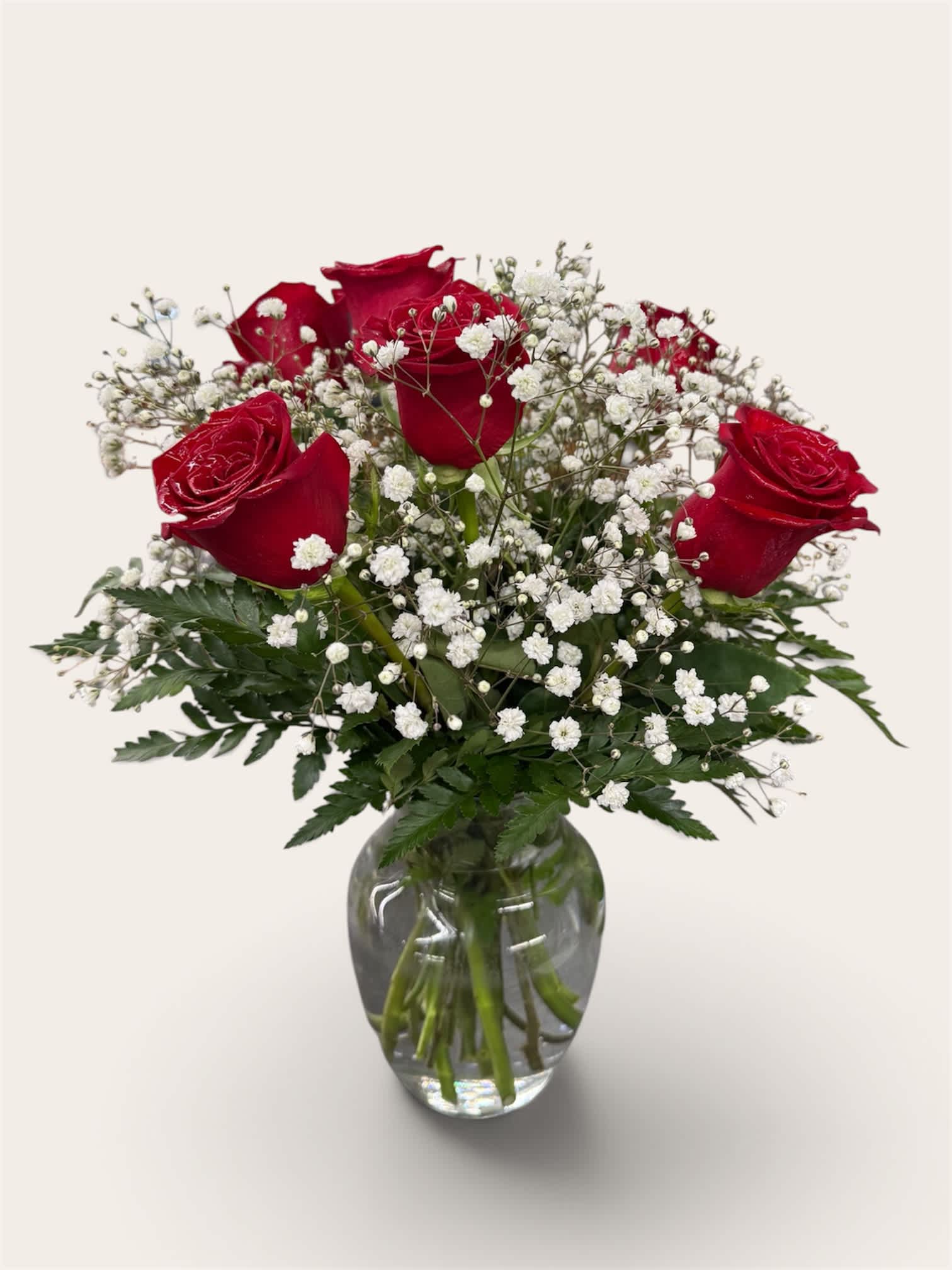 Red roses and baby's breath in a clear glass vase