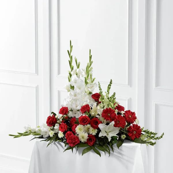 Red and white floral centerpiece with tall white blooms on a table
