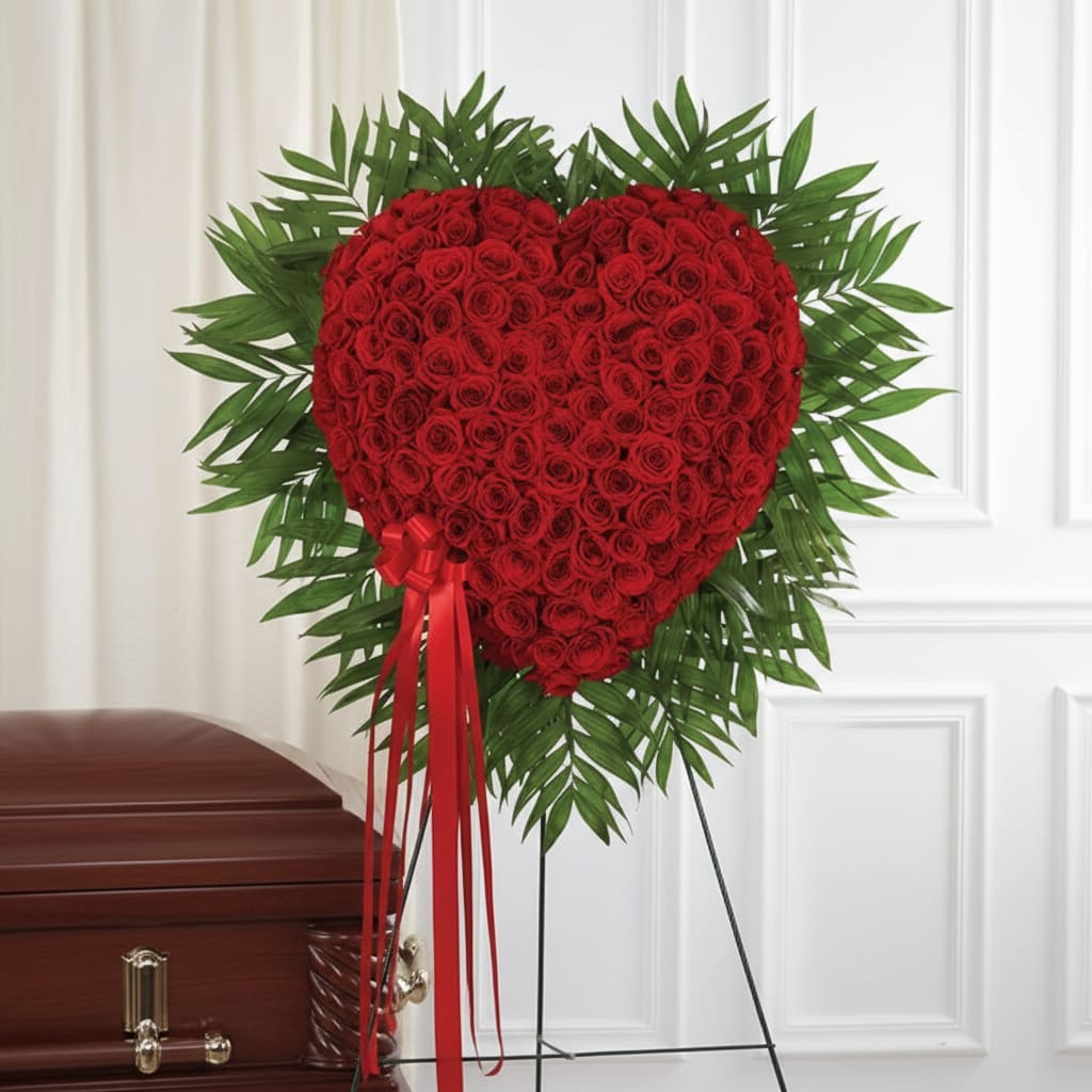 Heart-shaped red rose standing spray with a red ribbon on an easel