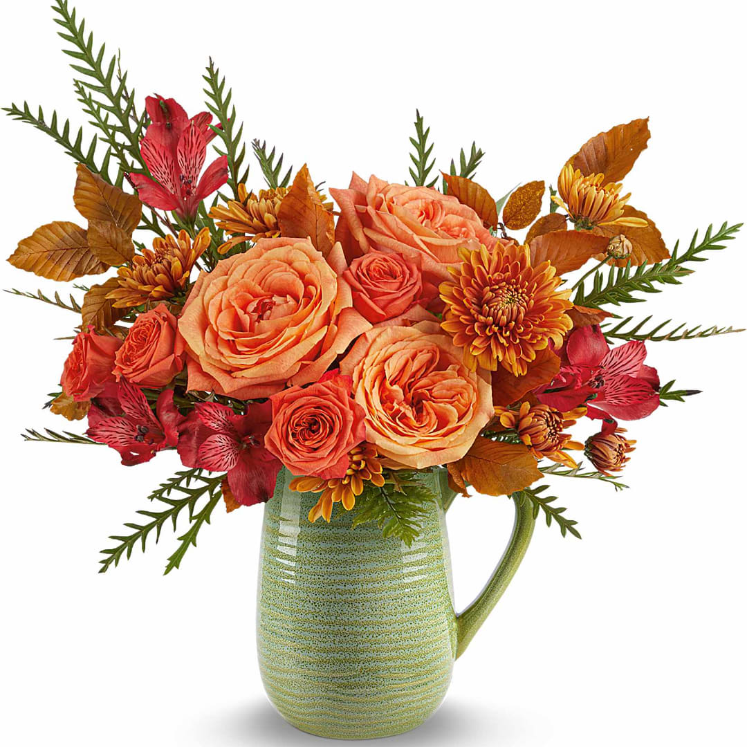 Orange roses and red alstroemeria in a green ceramic pitcher