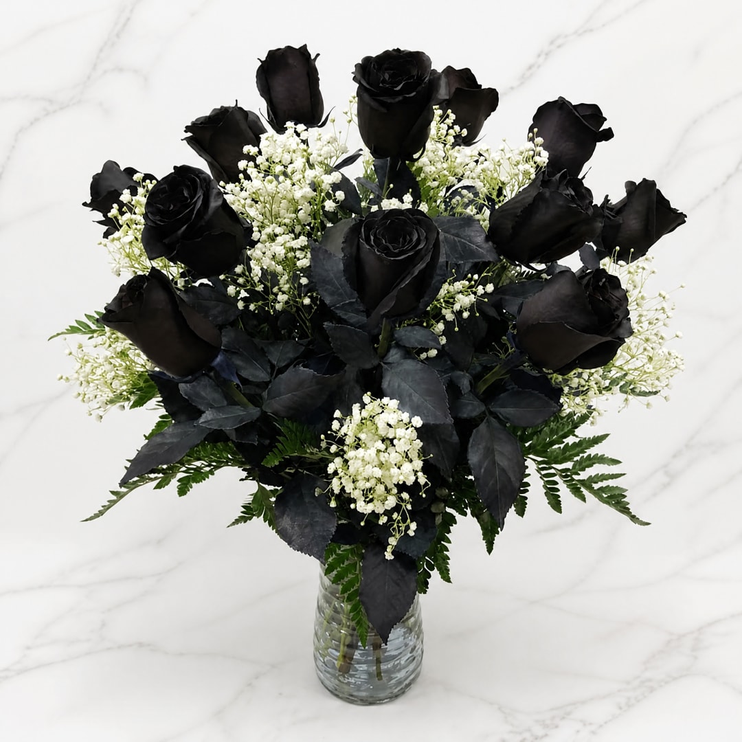 Black roses with white baby's breath in a clear glass vase