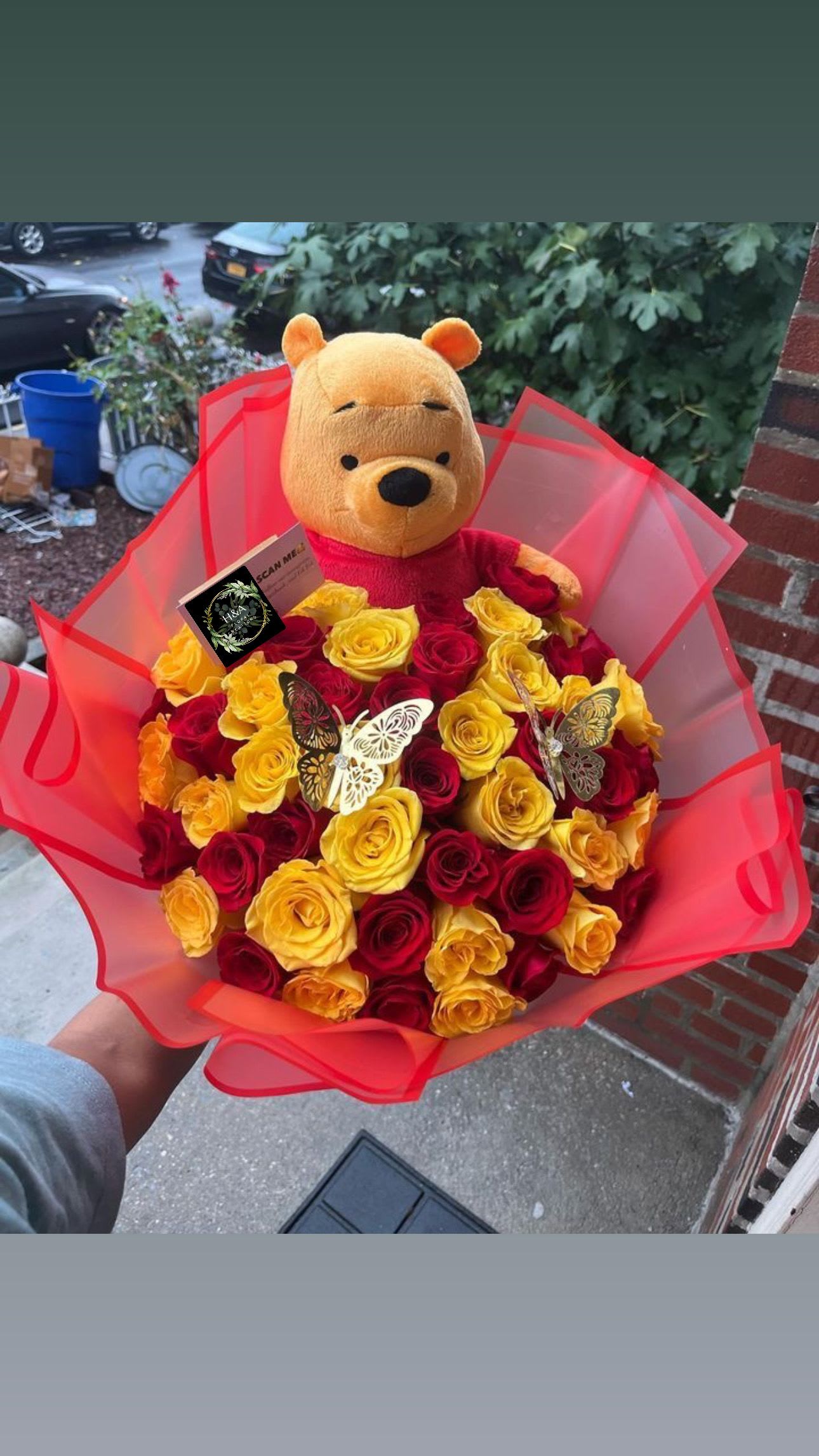 Bouquet of red and yellow roses with a Winnie the Pooh plush