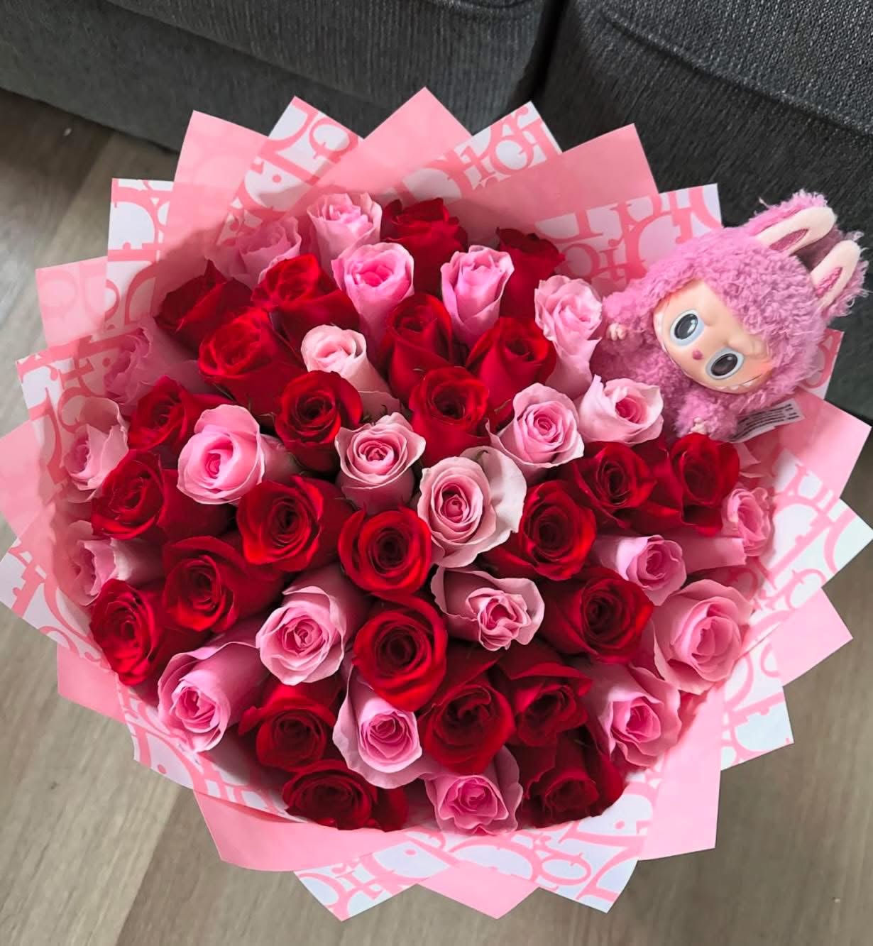 Bouquet of red and pink roses with a pink plush toy
