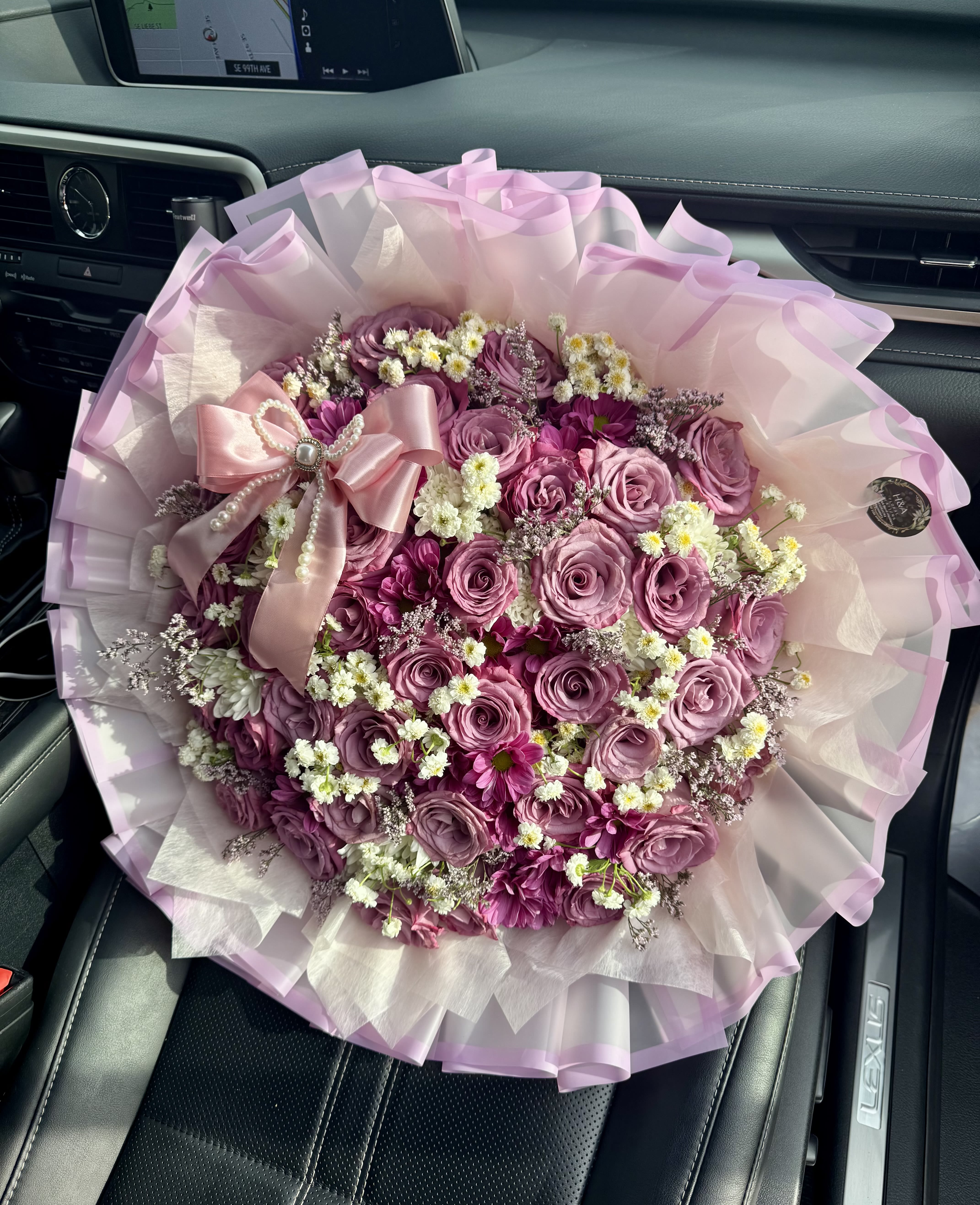 Pink rose bouquet with small white filler flowers and a satin bow