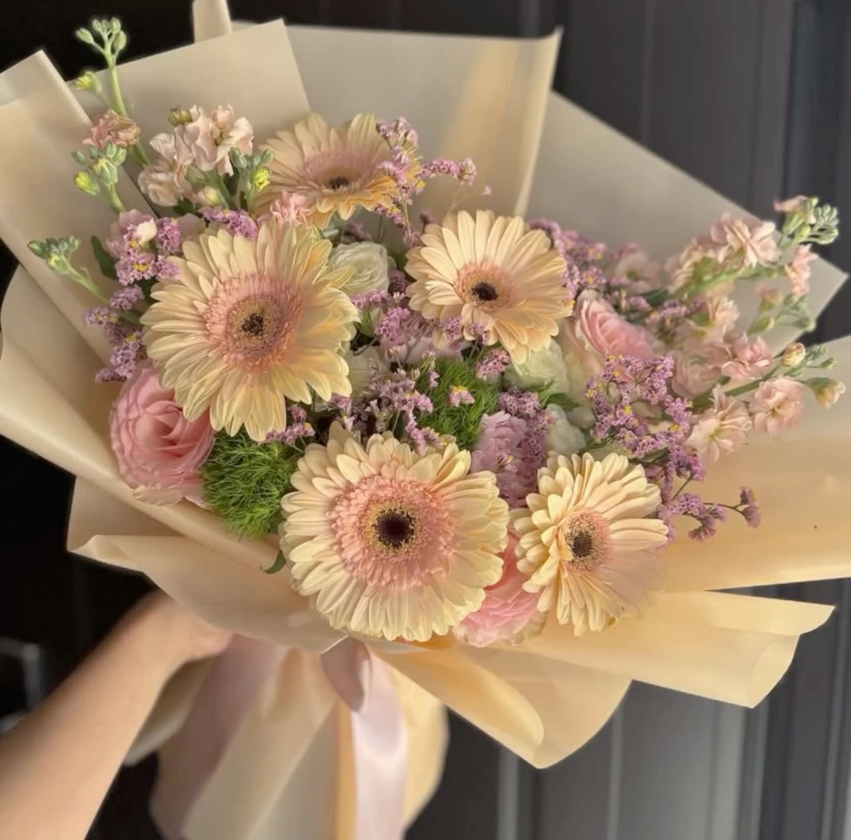 Bouquet of pale pink and cream gerbera daisies with pink roses